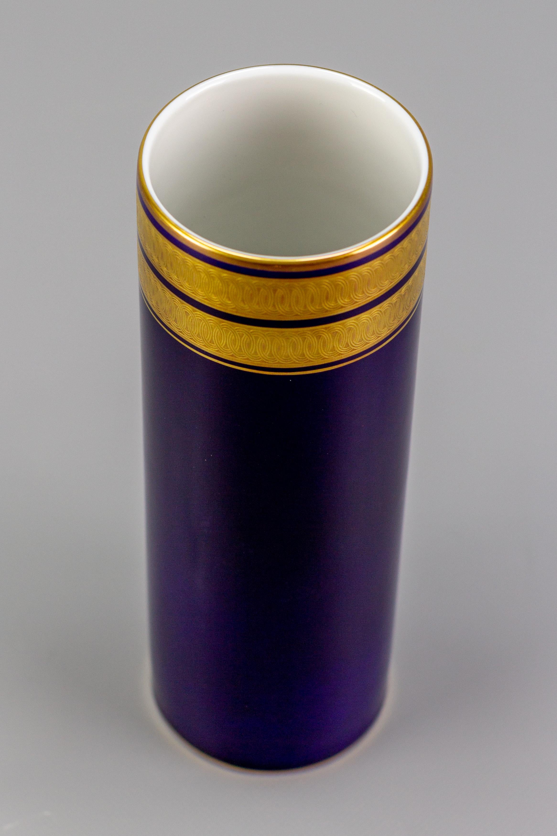 An elegant vase by Hutschenreuther, Germany, 1970s. Cobalt blue, golden ornate trim. Underglaze green maker's mark and numbers 138/23 and 604502 on the underside. 
Dimensions: height: 25.5 cm / 10.04 in; diameter: 8 cm / 3.15 in.