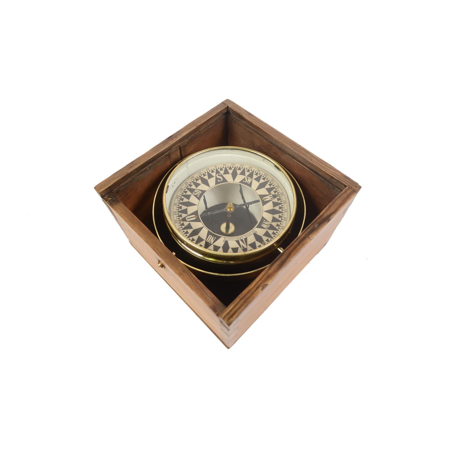 Large dry compass placed in its original wooden box with slot lid. Signed AUG. CARSTENS Hamburg Steinhöft 19 from the second half of the 19th century. The compass consists of a brass and glass vessel on the bottom of which a metal stem is fixed on