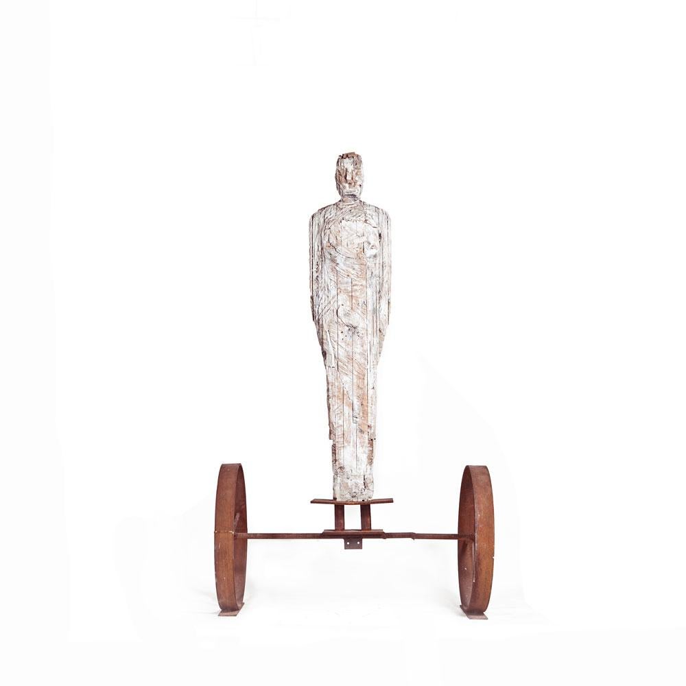 Große freistehende männliche Figur aus Holz, geschnitzt auf rostfarbenem Eisenradständer