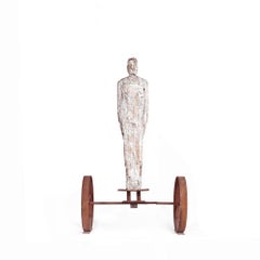 Large Standalone Male Figure Wood Carved on Rusted Iron Wheels Stand