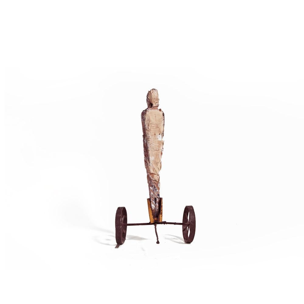 Standalone männliche Figur aus Holz, geschnitzt auf rostfarbenen Eisenrädern mit Griff – Sculpture von German Consetti