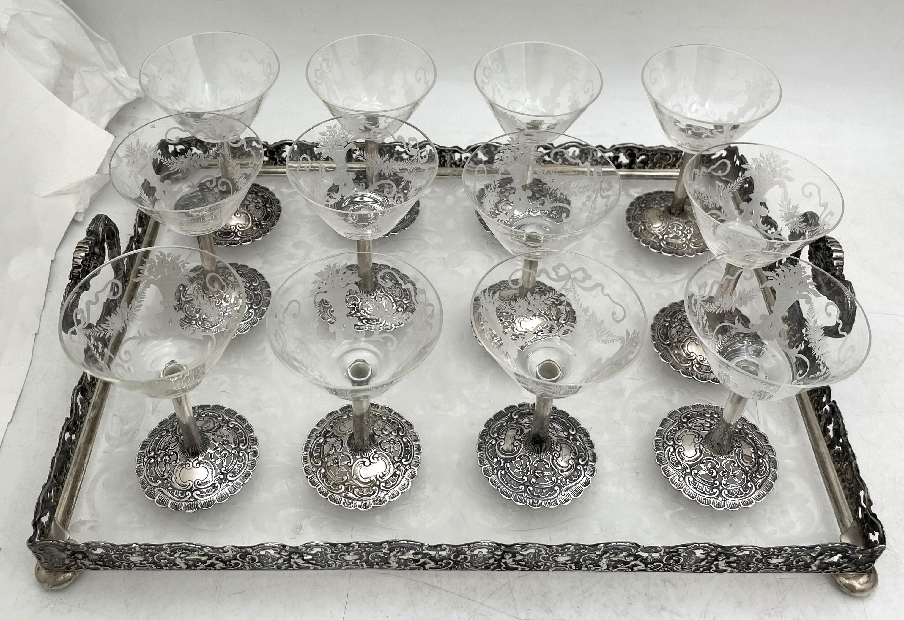 German, continental silver and beautifully etched glass set from the late 19th century, consisting of a two-handled gallery tray, standing on 4 balled feet, measuring 14 3/4'' in length by 11'' in width by 3 1/8'' in height, and 12 matching sherbert