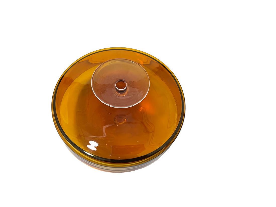 German crystal glass lidded box by Heinrich, Löffelhardt, 1950s

An orange colored crystal lidded box, which is used for cookies. The lid can act as a bowl if you turn it over. The knob on the lid can be used as a knob or as a foot base, designed by