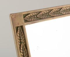 German designer. Art Nouveau table mirror in brass with relief leaves.