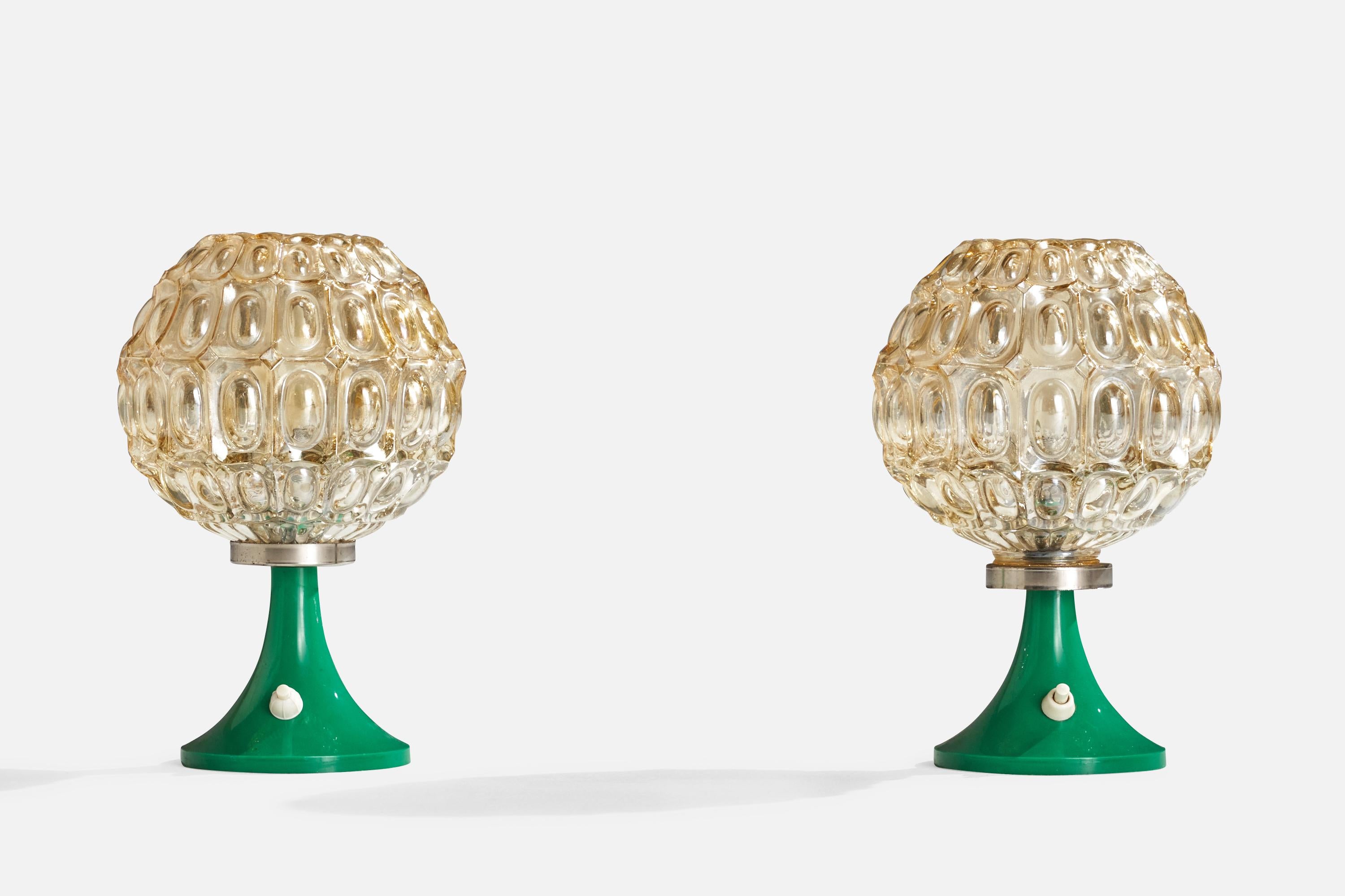 A pair of glass, metal and green acrylic table lamps designed and produced in Germany, c. 1970s.

Overall Dimensions (inches): 9.5” H x6.5”  D
Stated dimensions include shade.
Bulb Specifications: E-14 Bulb
Number of Sockets: 2
All lighting will be