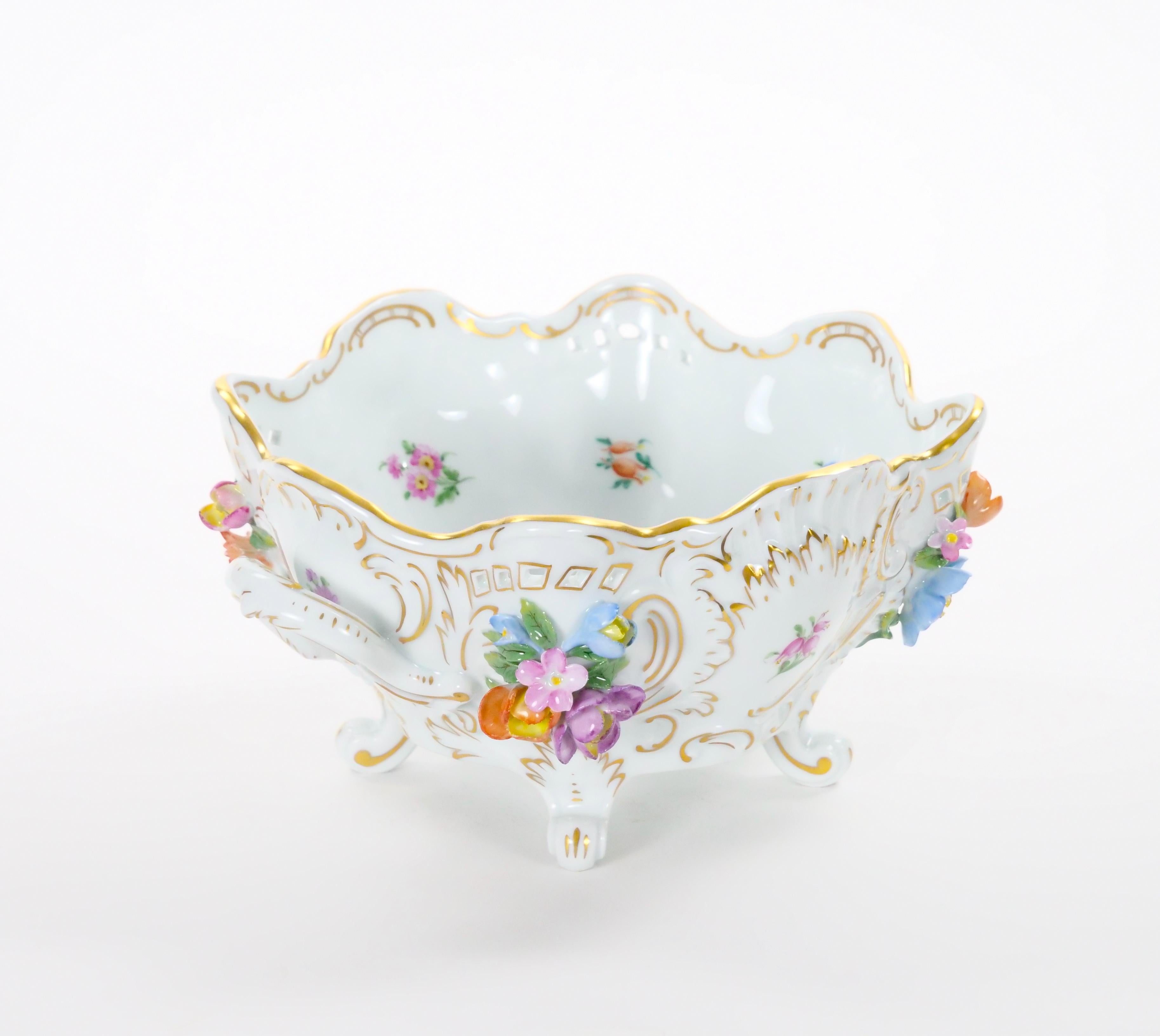 Exquisito ejemplo de la artesanía de la porcelana fina alemana, este cuenco con pie de centro reticulado de mediados del siglo XX fue creado por la estimada Dresden Porcelain Company. Elegante y rica en detalles, muestra el refinado arte por el que
