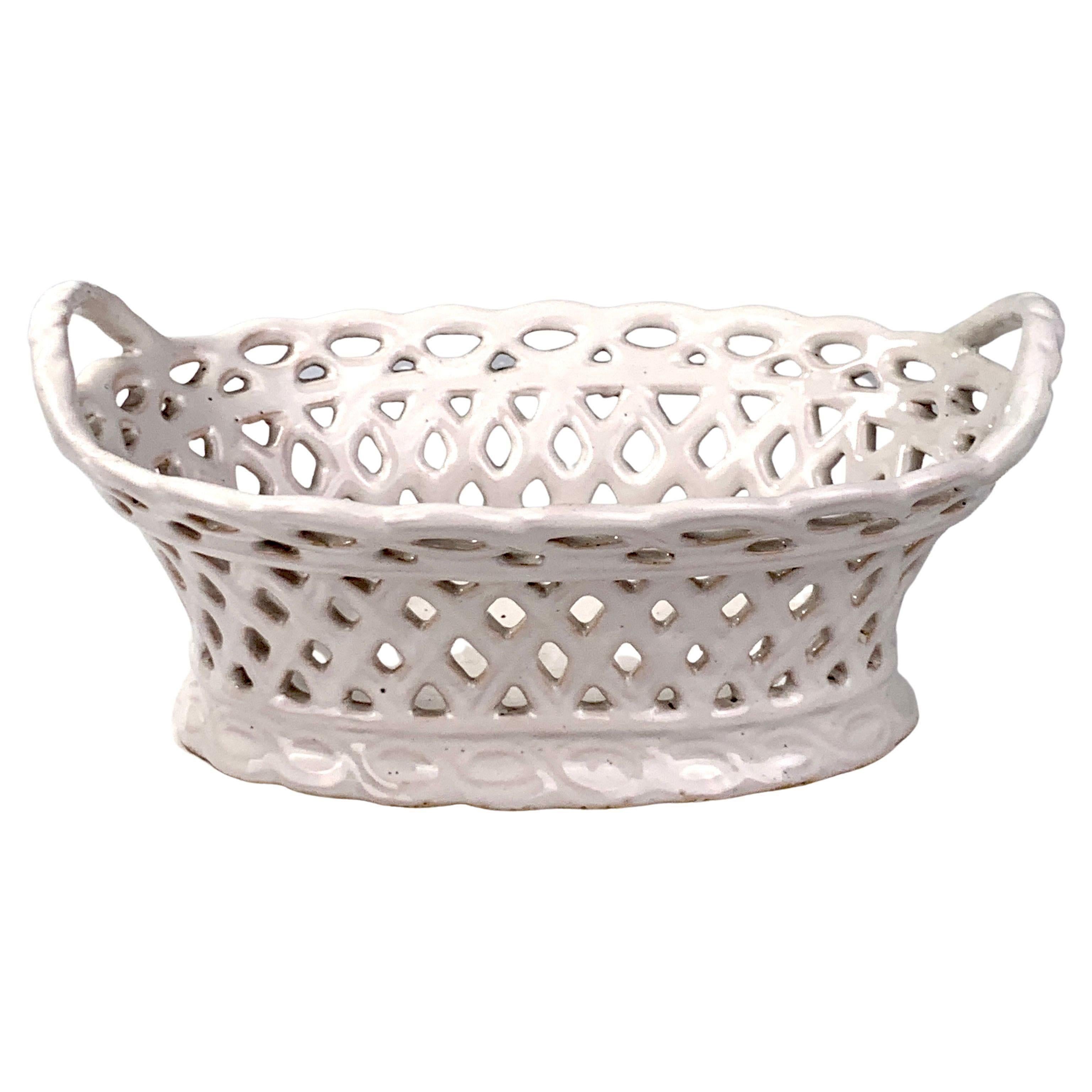 This attractive white faience basket has an oval pierced body around a solid bottom. It was manufactured at the Durlach factory in Germany.
The basket is modeled in a wicker basket style, a popular motif for late 18th and early 19th-century
