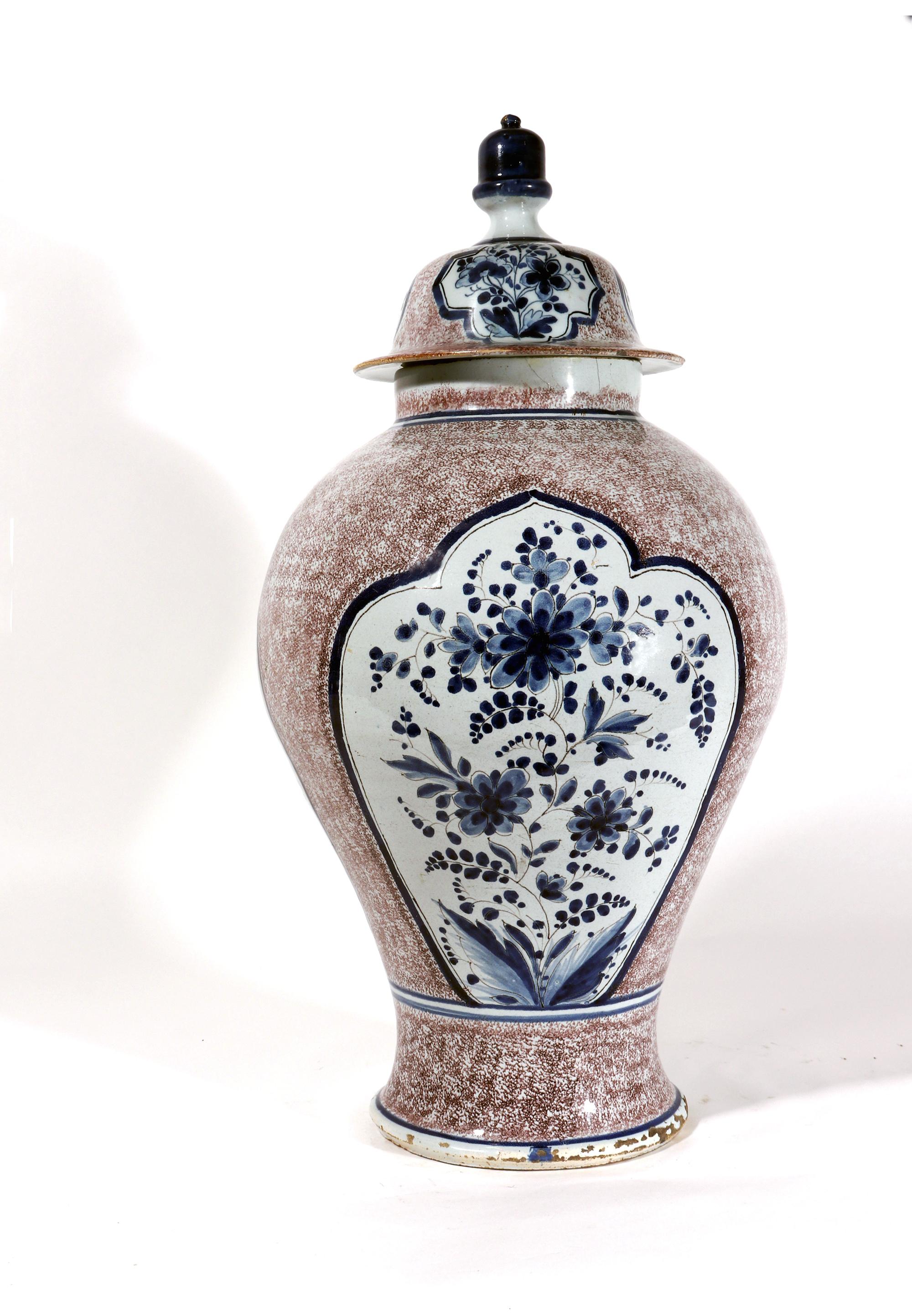 Massive German Faience or Dutch Delft Powdered manganese & blue vase & cover,
Mid-18th Century,

The German faience powered manganese-ground vase, of baluster form, has a wide shoulder with sloping sides narrowing to a flared foot. To front and back