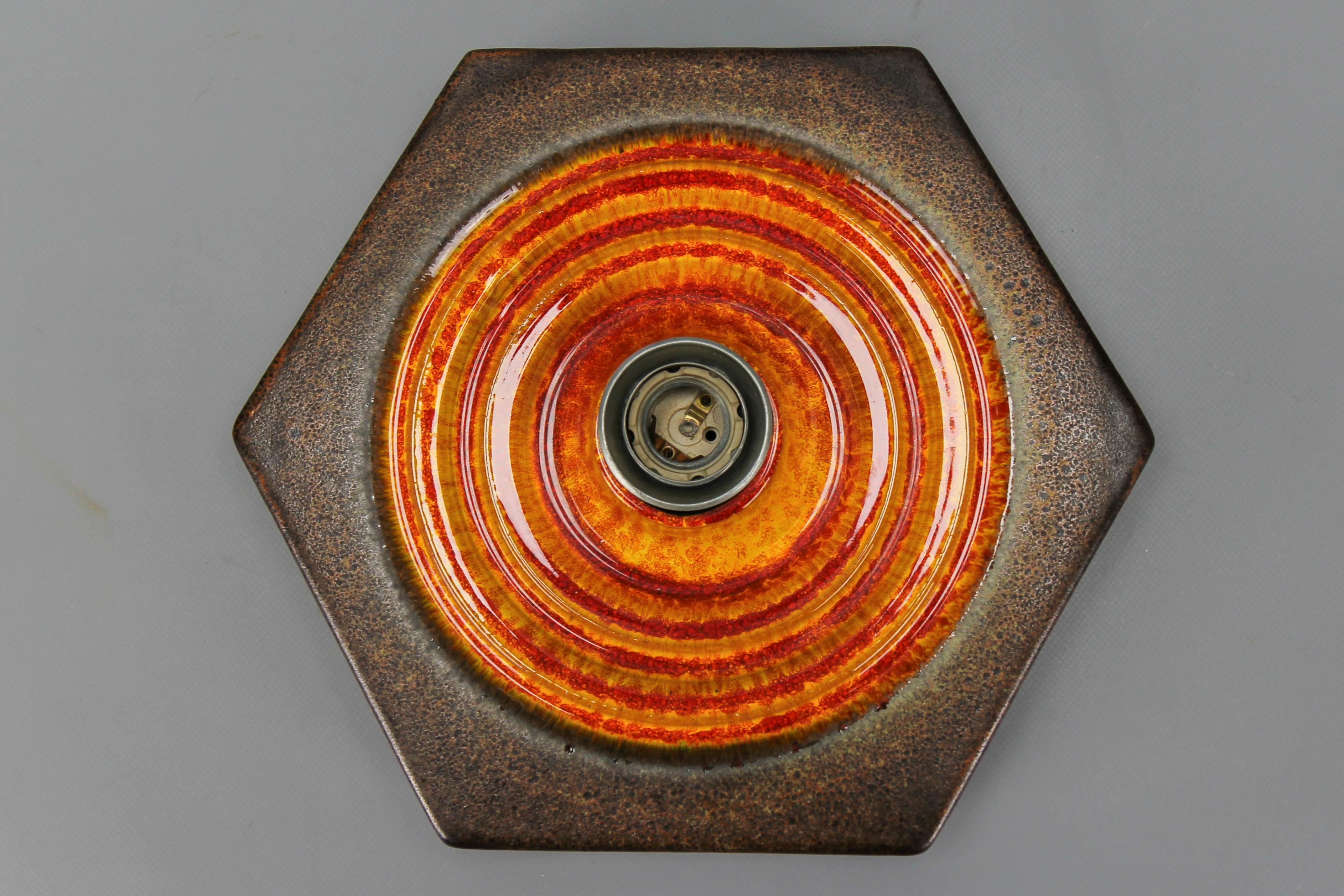 German fat lava orange and brown ceramic flush mount or sconce, 1970s.
A beautiful German Ceramic Fat Lava or West German Pottery, Modernist period, hexagonal ceramic flush mount or wall light in orange, brown, and red tones. Single light - one