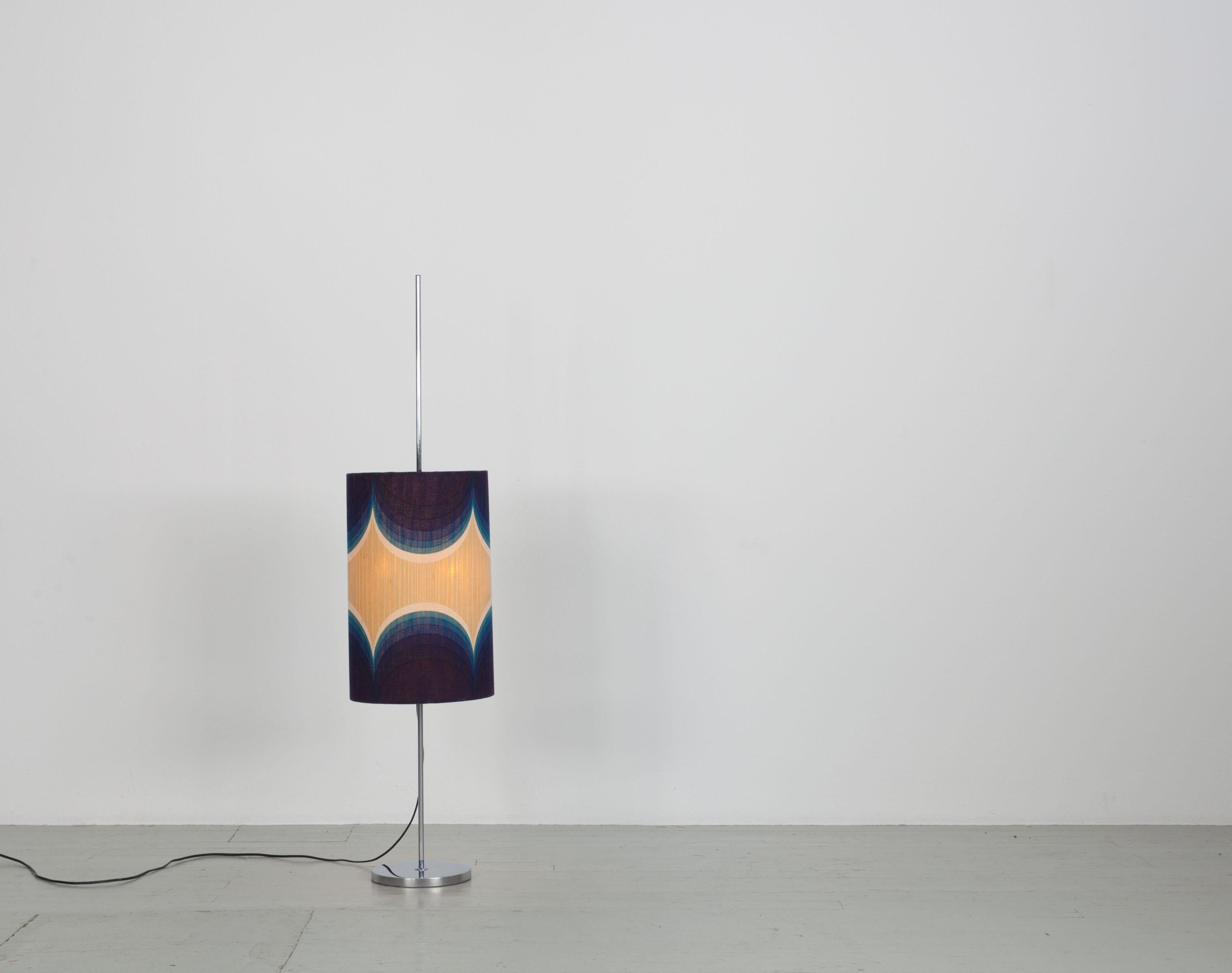 German floor lamp from the 70s. The lamp has an original, height-adjustable lampshade, in the typical 70s pattern. The lamp base is made of chrome. The lamp has two E27 sockets. It has a height of 60cm and the diameter of the lampshade is 33cm.
