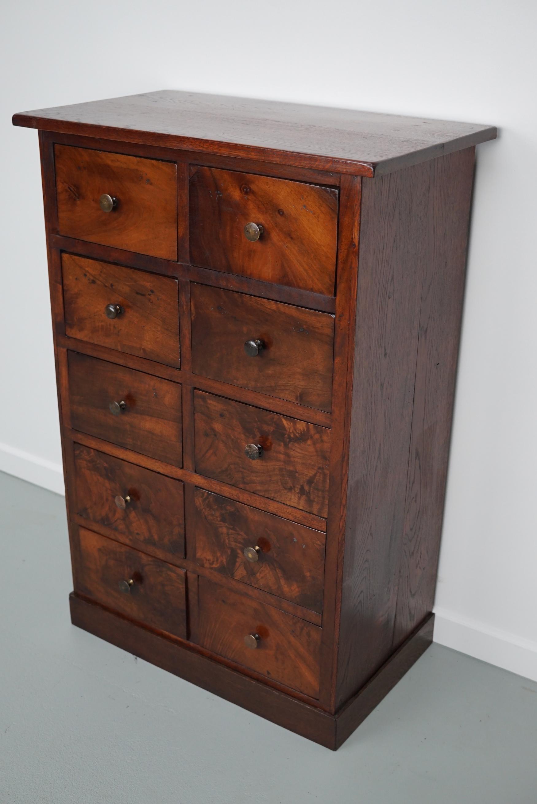 This cabinet was made around the second half of the 19th century from flower mahogany and oak. It was used to store herbs and medicine. It remains in a good and functional condition. The interior dimensions of the drawers measure: D 30 x W 22 x H 13