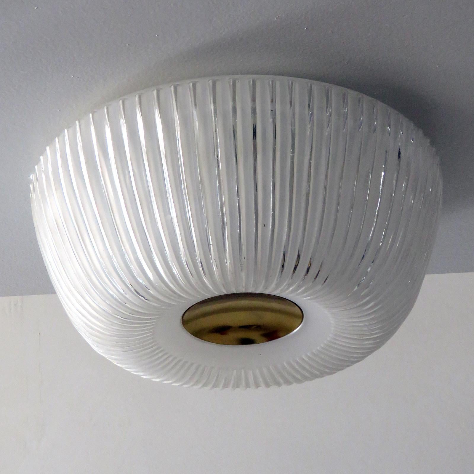Elegant, textured glass ceiling flush mount by Doria Leuchten Germany with a circular brass center and organically shaped glass body, wired for US standards, one E27 socket per fixture, max. wattage 60w or LED equivalent, bulb provided as a onetime