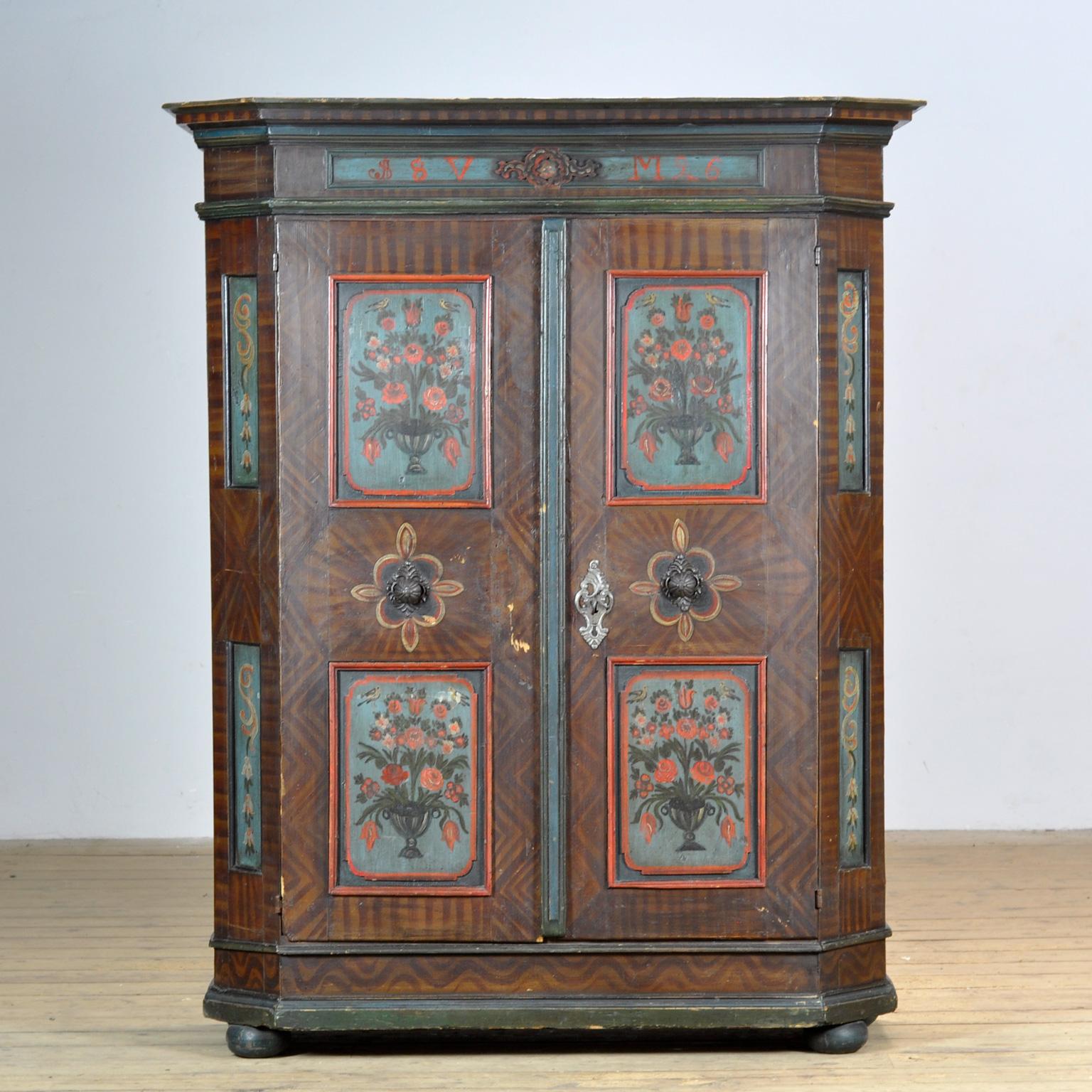 Une belle armoire du sud rural de l'Allemagne datant de 1826. L'armoire a été offerte en cadeau de mariage. Cette armoire est fabriquée en pin massif et est peinte à la main dans des couleurs vives. L'armoire possède ses charnières et sa serrure