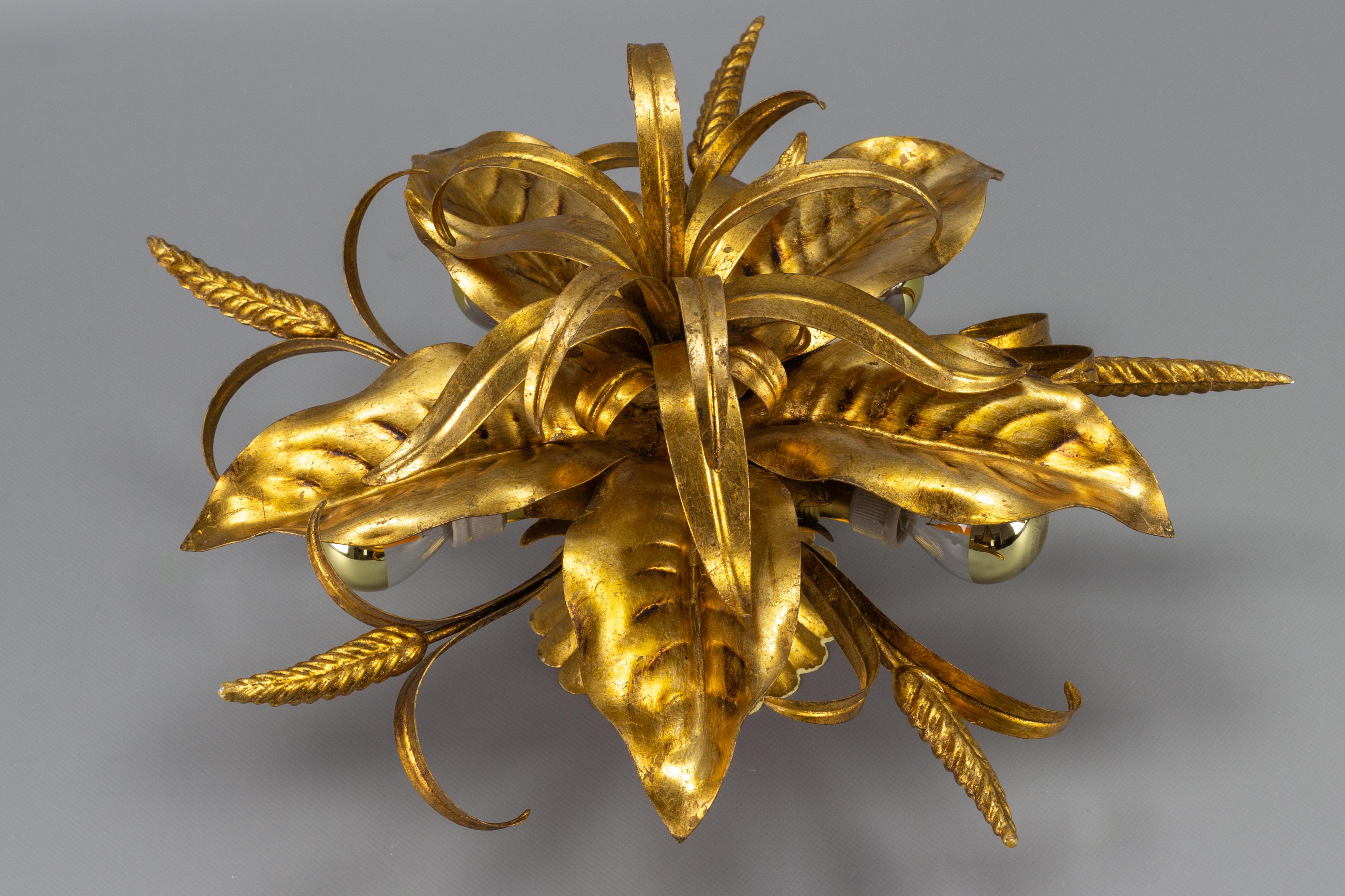 This adorable Hollywood Regency-style five-light gilt metal ceiling lamp features beautifully shaped leaves, wheat ears, and wheat leaves. 
Five hidden lights allow light to emit through stylized leaves, giving a warm background glow. A real