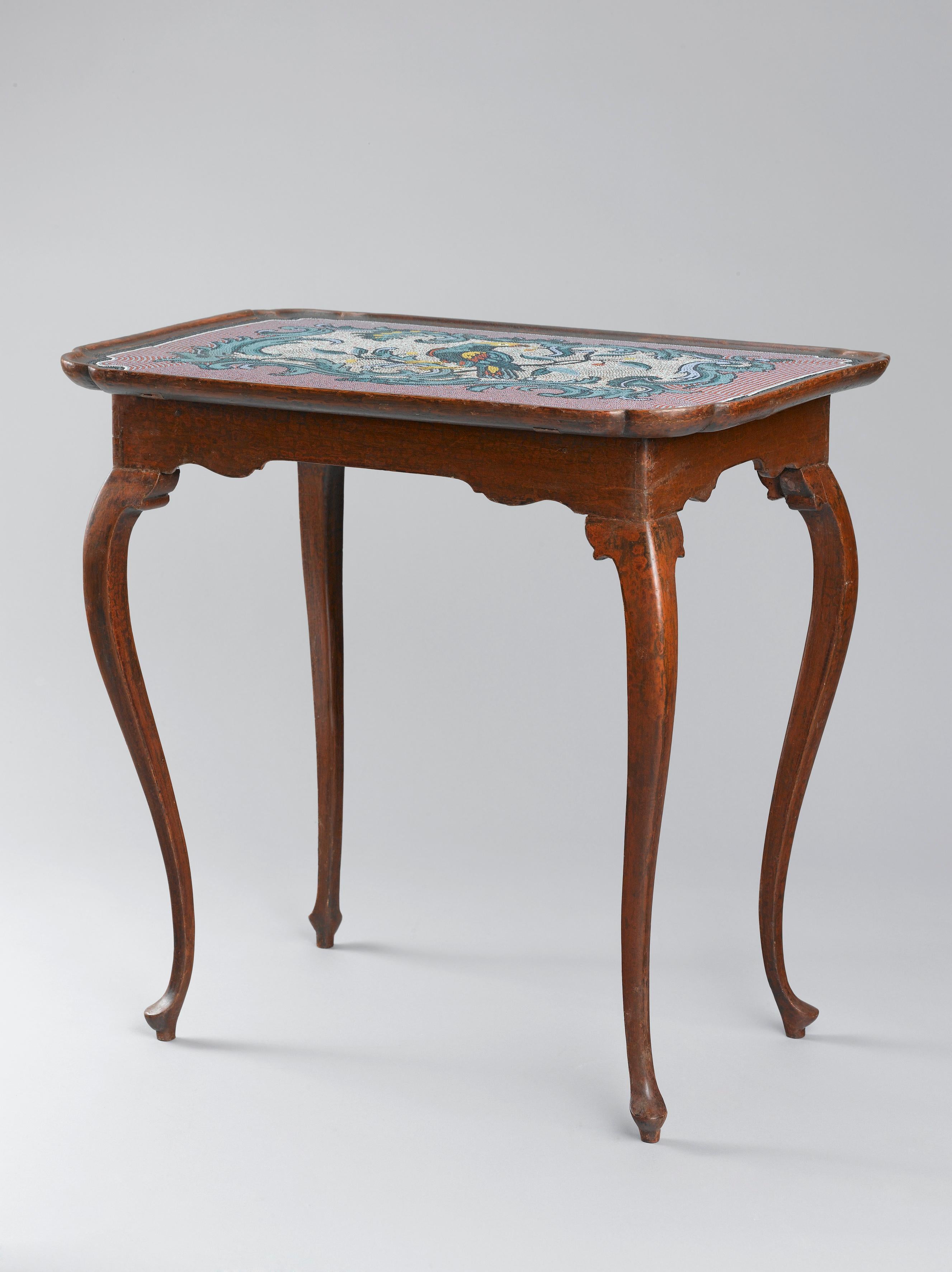 Oak and pine wood with historical paint and marbling. The rounded rectangular dished top with moulded edge and decorated with a mosaic made of glass beads depicting a parrot seated in a branch framed by scrolling foliage, above a plain frieze, on