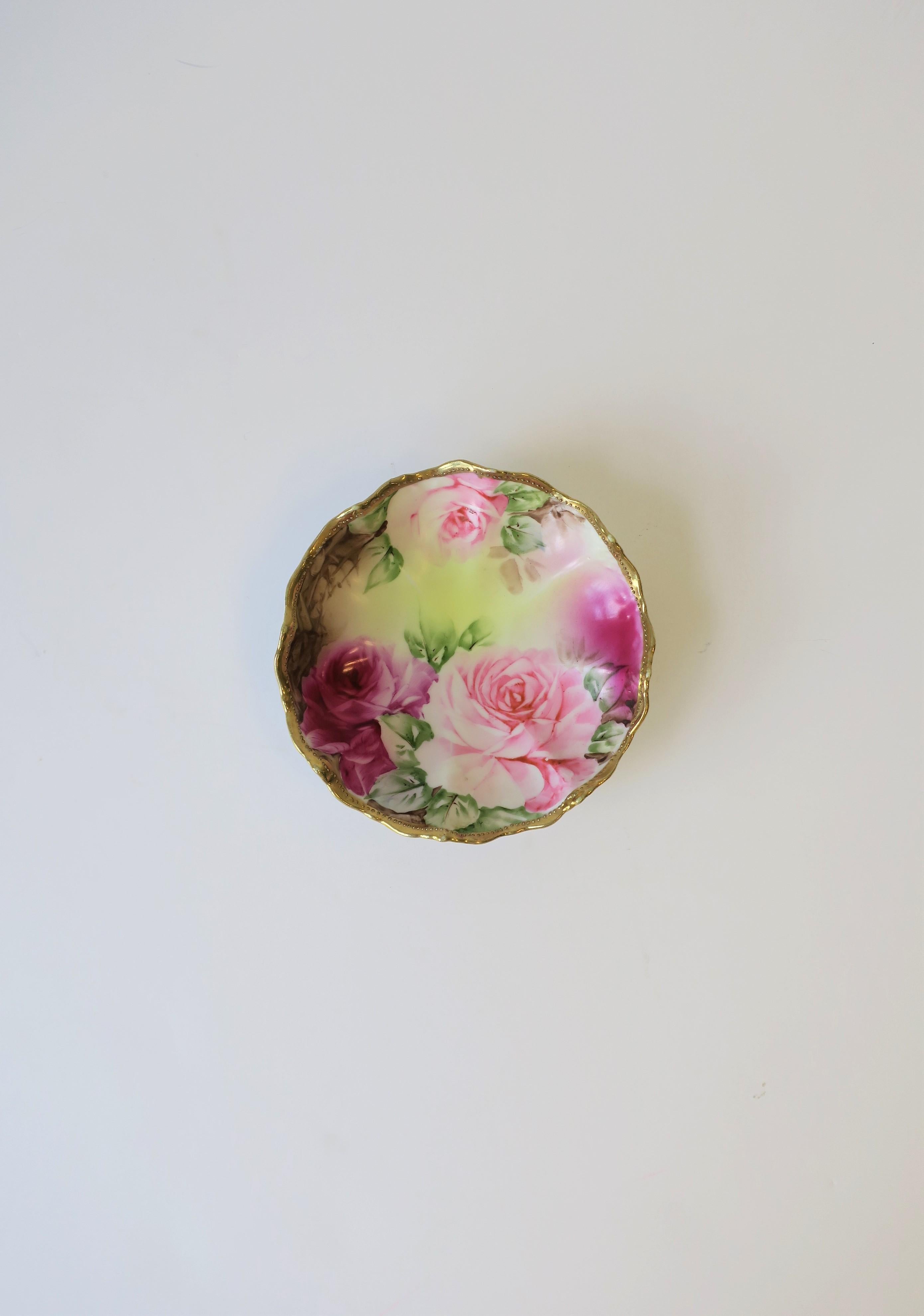 A very beautiful German porcelain ceramic jewelry dish, circa mid-20th century, Germany. This is a small dish with beautiful hand-decorated gold gilt detail around edge, and pink and fuchsia red roses with green leaves. Markers mark on bottom, but