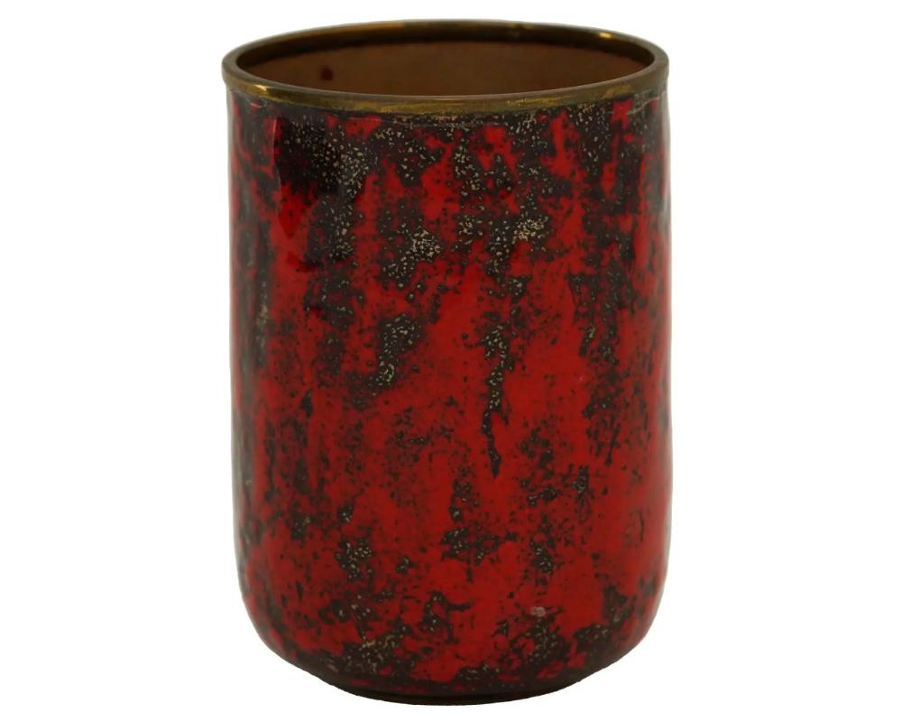A West German Graflich Ortenburg manner glaze over brass cup. The ware is covered with lava glaze in a red shade. Unmarked. Circa: 1960s to 1970s. Graflich Ortenburg were founded in 1946 and based in Tambach, Germany. They are known for the quality