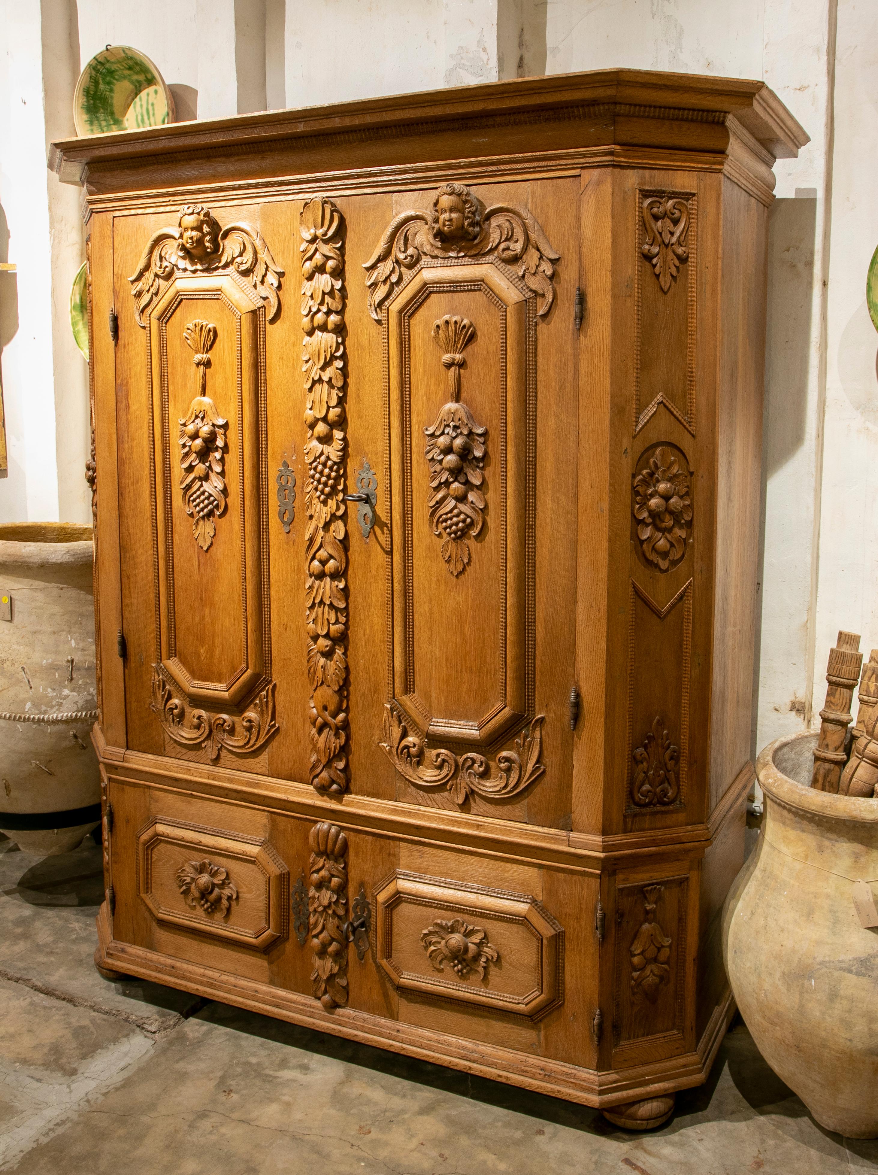 German hand carved wooden cupboard with fruit and angel scenes.