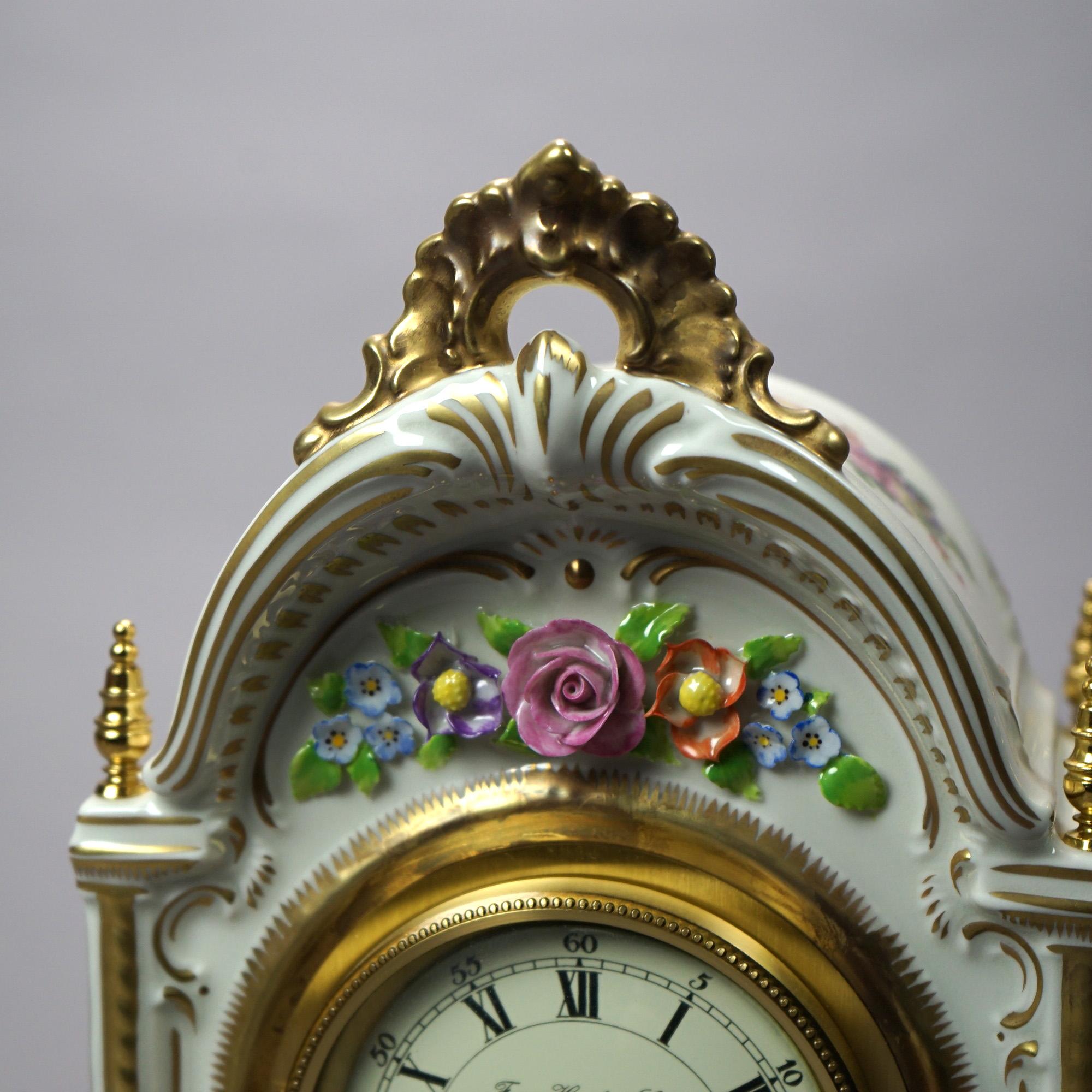 A German Franz, Hermle & John mantle clock offers porcelain construction with hand painted floral elements and gilt highlights throughout, raised on cabriole legs, maker and retailer marks on base and face, 20th century.

Measures - 12.5