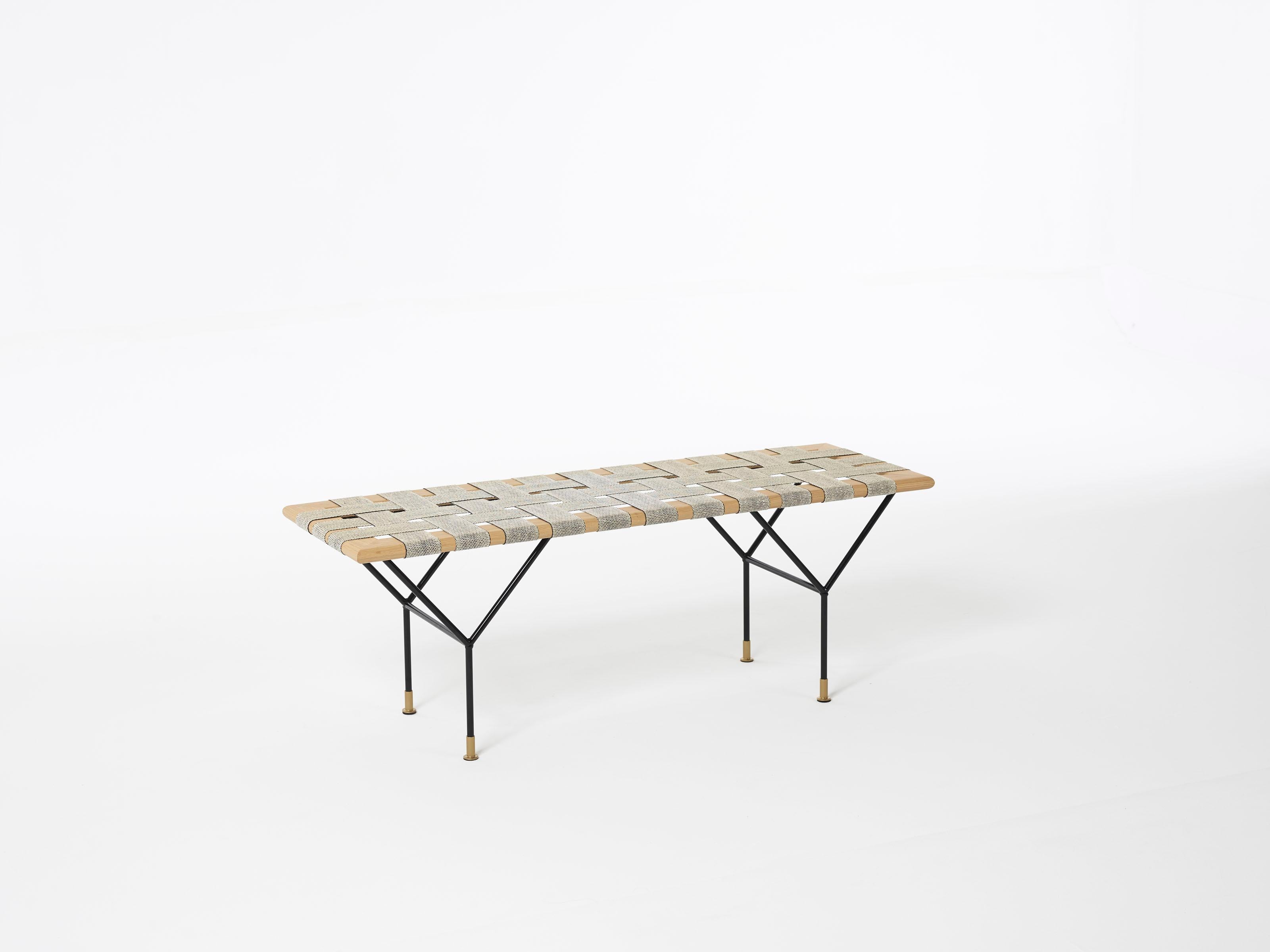 The bench is made of a filigree construction of powder-coated steel. On this construction rests a frame of solid, lacquered oak tree, which is covered with handwoven stripes of fabric made of jute and coco. This combination invites you to take a