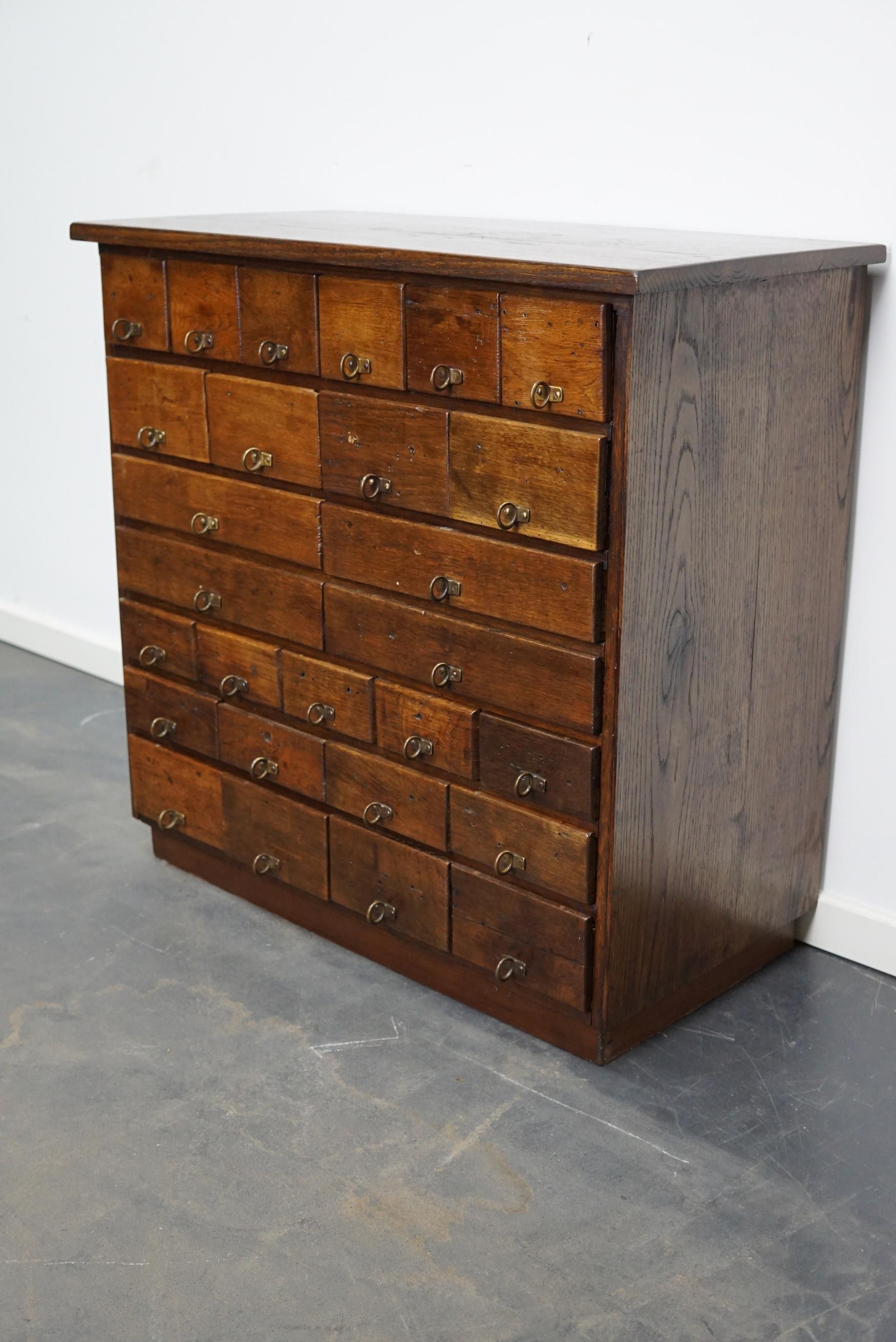 This apothecary cabinet was made circa 1930s in Germany and was later used in a hardware store in Belgium until recently. It features many drawers in different sizes with metal handles.