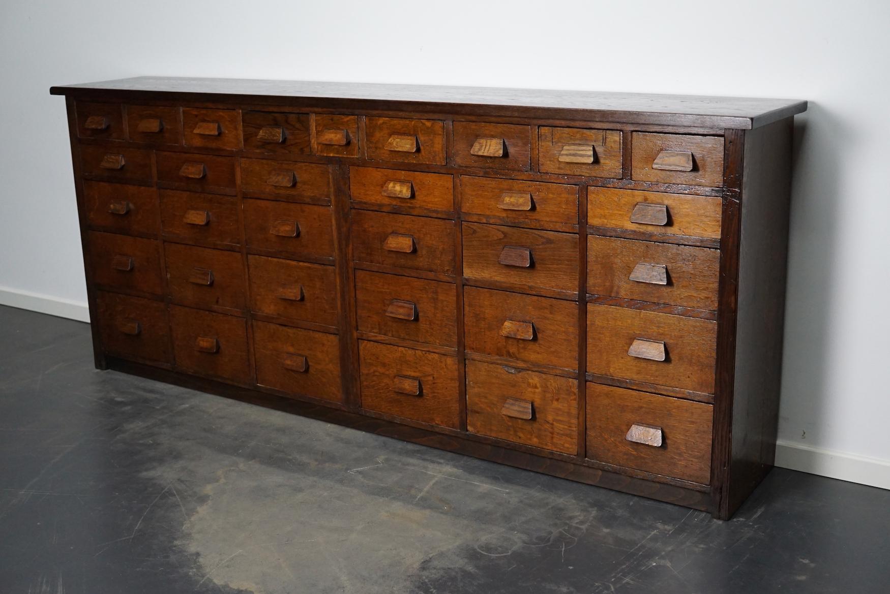 This apothecary cabinet was made circa 1930s in Germany and was later used in a hardware store in Belgium until recently. It features many drawers in different sizes with oak handles.
 