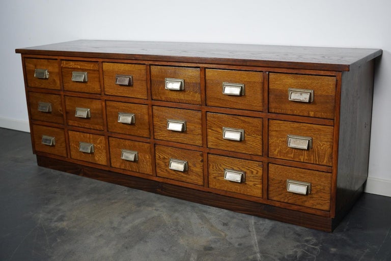 This apothecary cabinet was made circa 1950s in Germany. It features 18 decent sized drawers with metal handels. The interior dimensions of the drawers are: D W H 38 x 21 x 13 cm. This item could very well be used as a tv cabinet / lowboard.