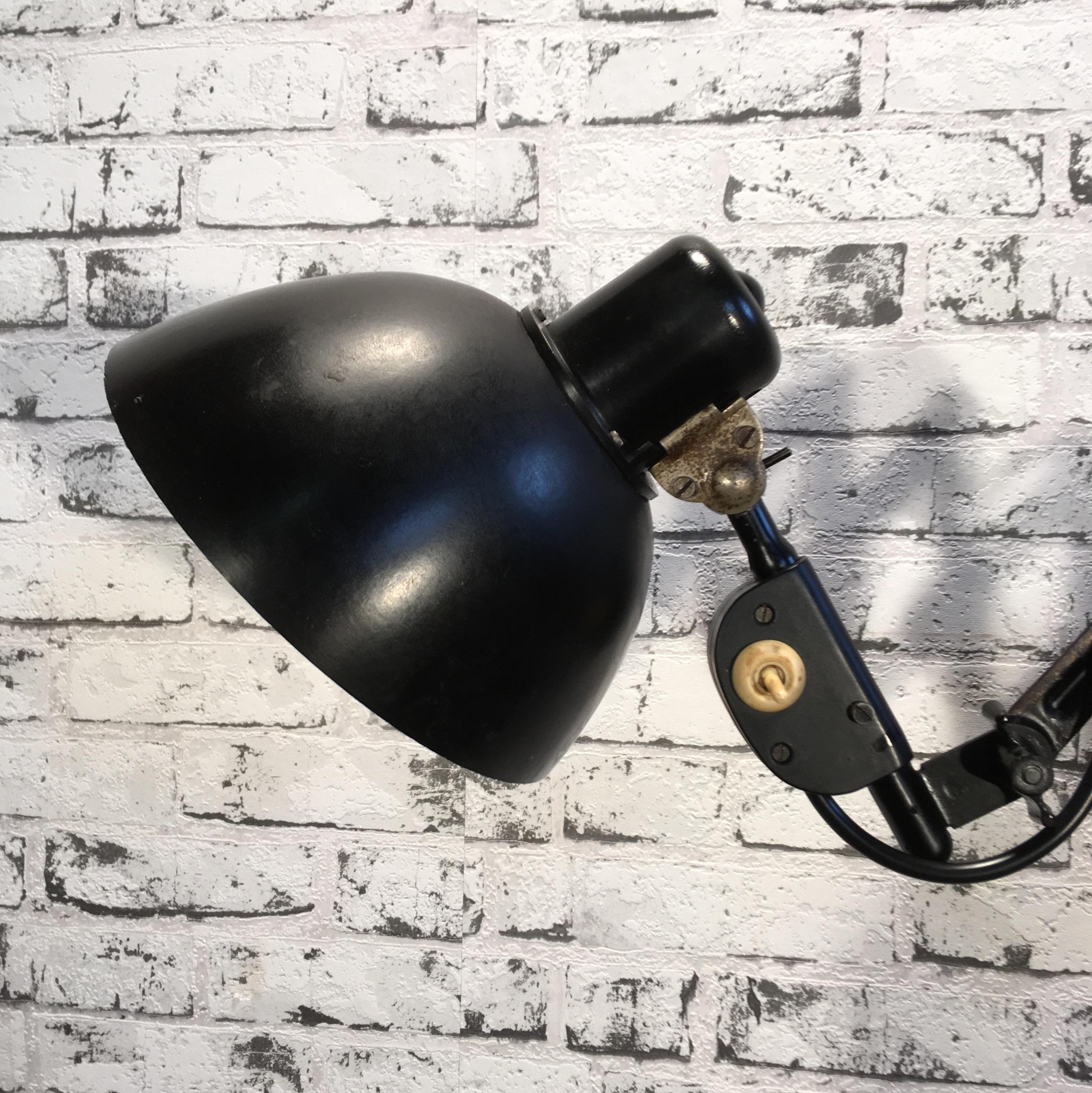 This vintage industrial scissor lamp was produced by Reif Dresden in former East Germany in the 1950s.Lamp has black Bakelite shade. Black iron scissor arm is extendable and can be turned sideways. Socket for E 27 bulbs. Fully