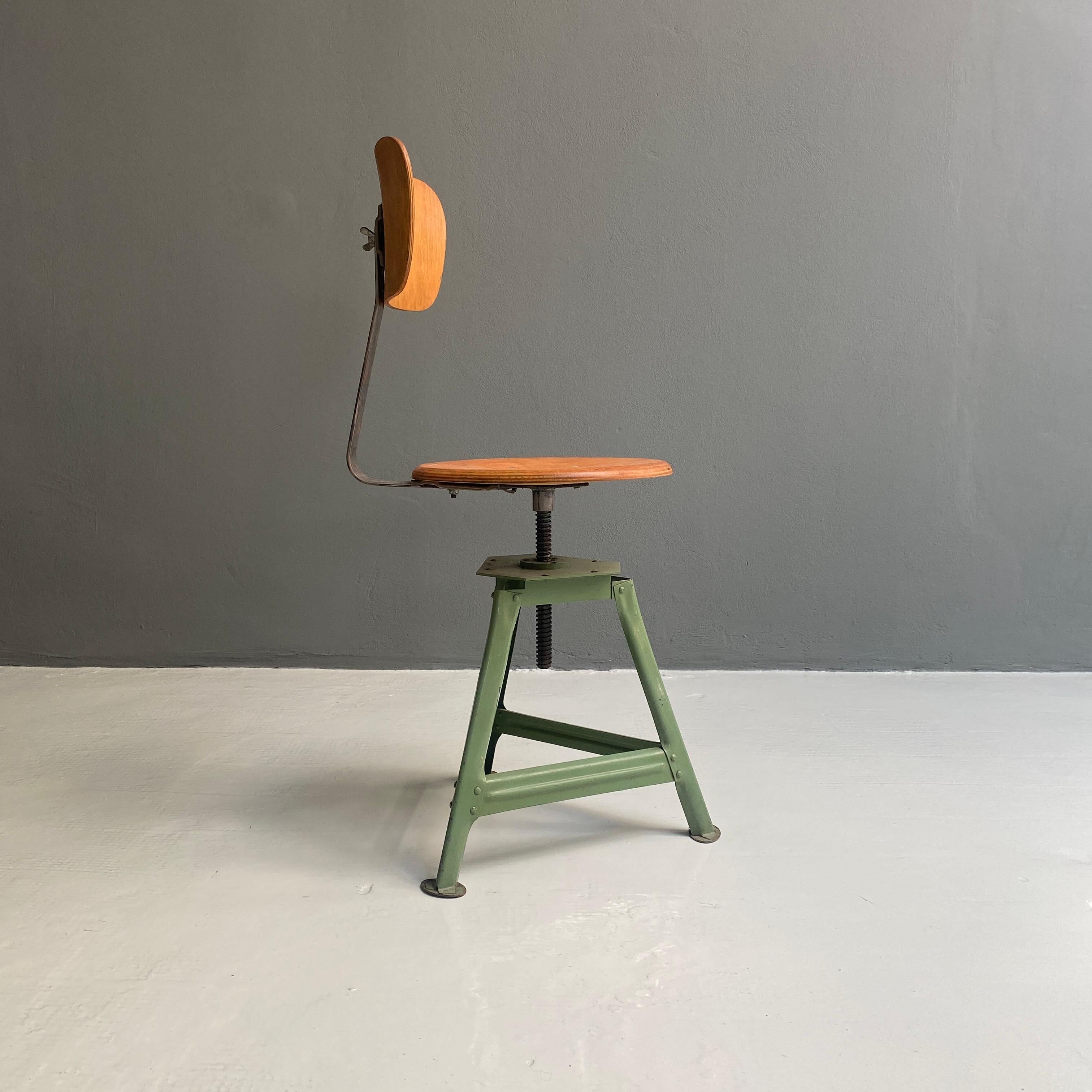 Industrial wood and metal chair, 1930s.
Industrial chair with backrest and adjustable seat in shaped plywood and frame in riveted steel and painted green at the base.
1930s.

Good conditions.

Measurements in cm 40 x 47 x 86 H.