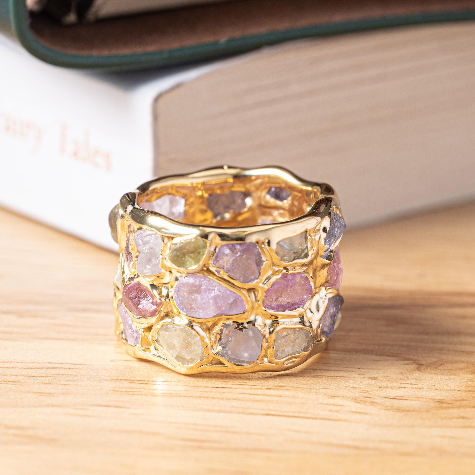 Elara è pensata per le persone che vogliono gioielli reali, tattili e vicini alla Nature. Questo anello a barilotto utilizza grandi zaffiri grezzi di colori misti (zaffiri fantasia) nel loro stato naturale: nessun taglio, nessuna lucidatura, solo le