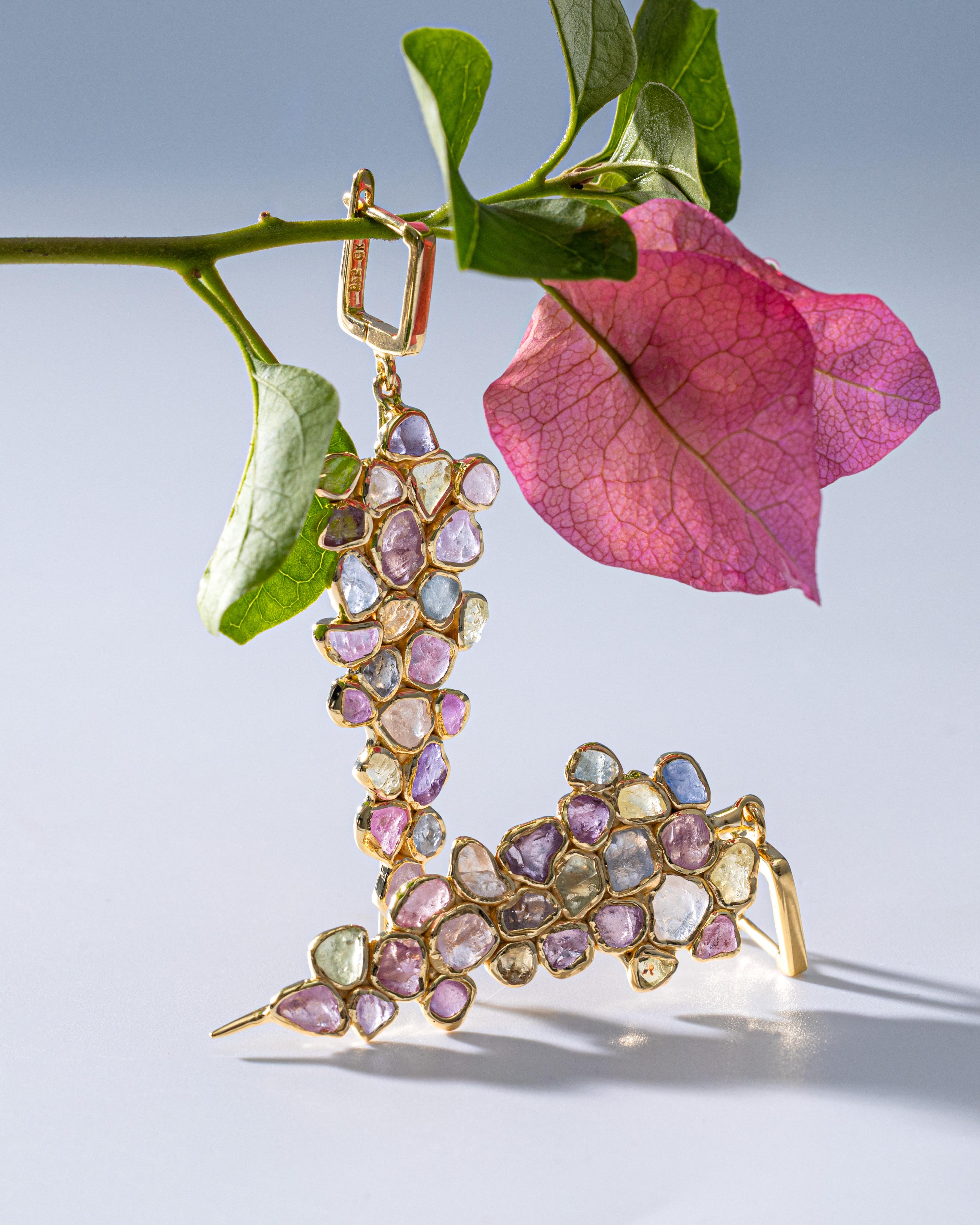 Tarina prend l'idée d'une boucle d'oreille pendante et la transforme en quelque chose de sculptural. Les pierres forment une grande grappe en cascade - une 