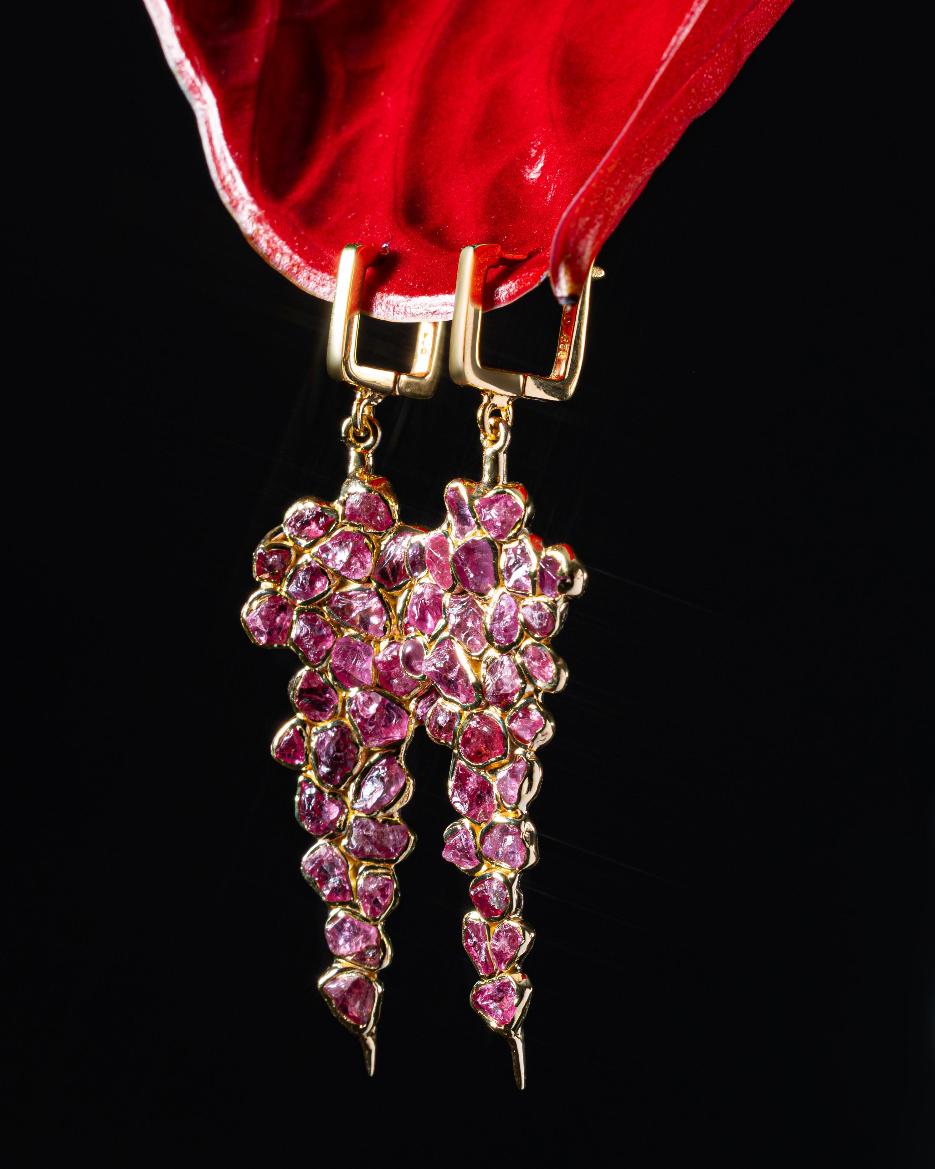 Tarina está diseñada como un gran racimo colgante de cristales de espinela rosa en bruto: una gota llena, en forma de uva, hecha totalmente de piedras naturales. Cada espinela se utiliza exactamente como viene de la tierra, con su tono rosa original