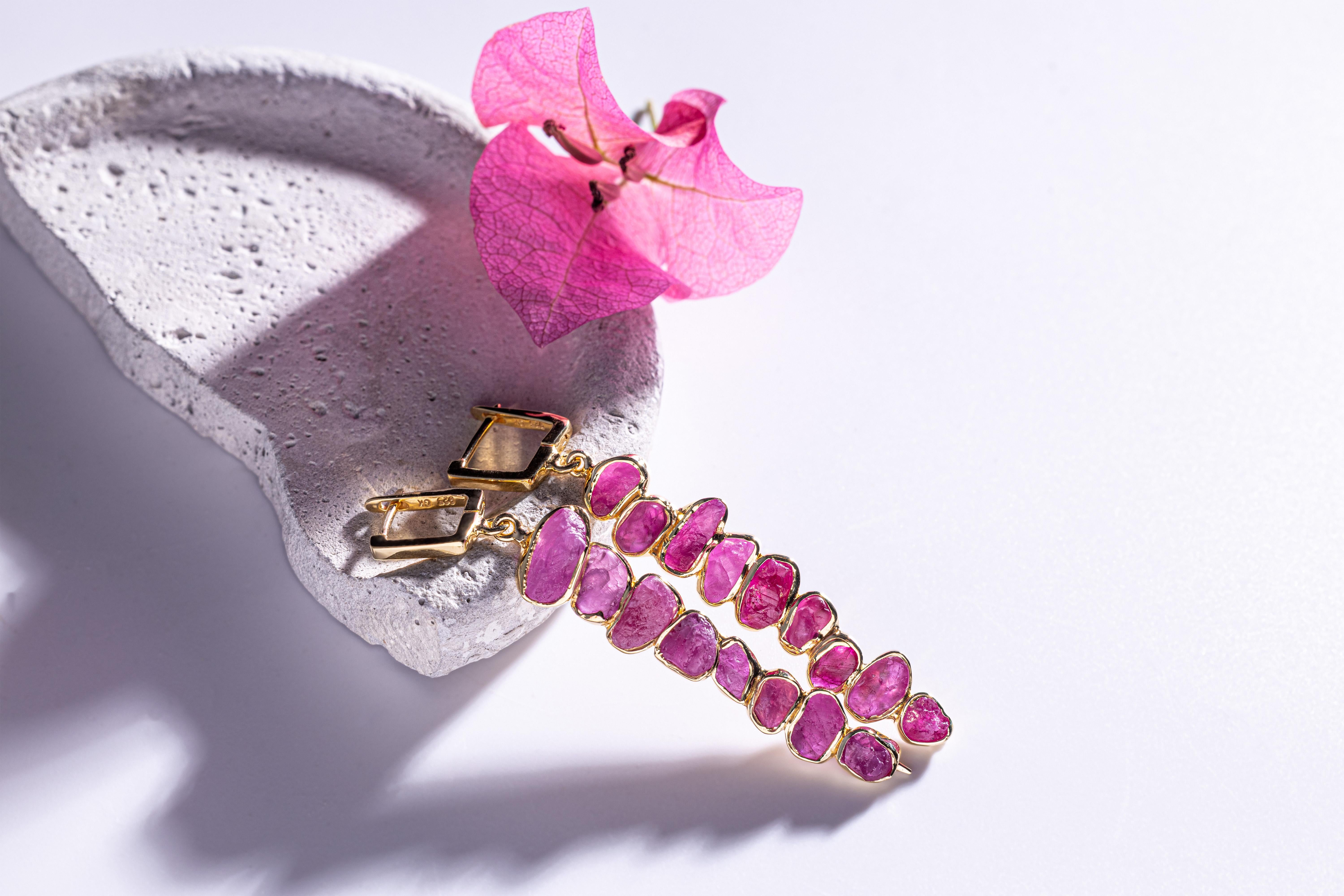 Gli orecchini Thera presentano cristalli di rubino grezzo disposti in un grappolo allungato e sciolto che crea una silhouette moderna e sorprendente. I rubini sono lasciati completamente al naturale - senza lucidatura o taglio - così i loro toni