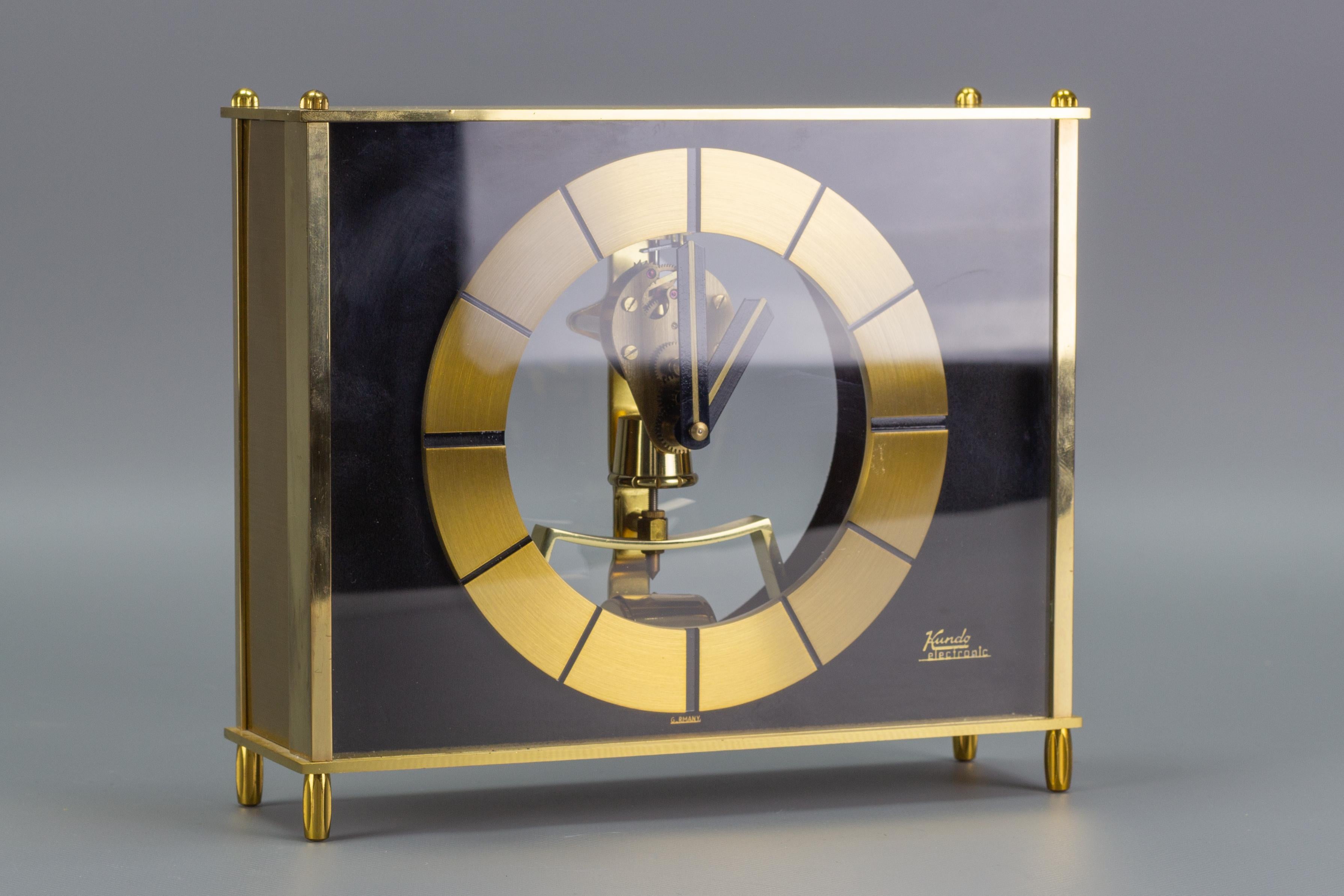 Absolutely stunning and rare, uniquely designed Kundo electronic magnetic pulse powered desk or mantle clock, producer Kieninger & Obergfell, Germany, the 1960s. Partly transparent, in golden brass and black color, rather heavy construction.
The