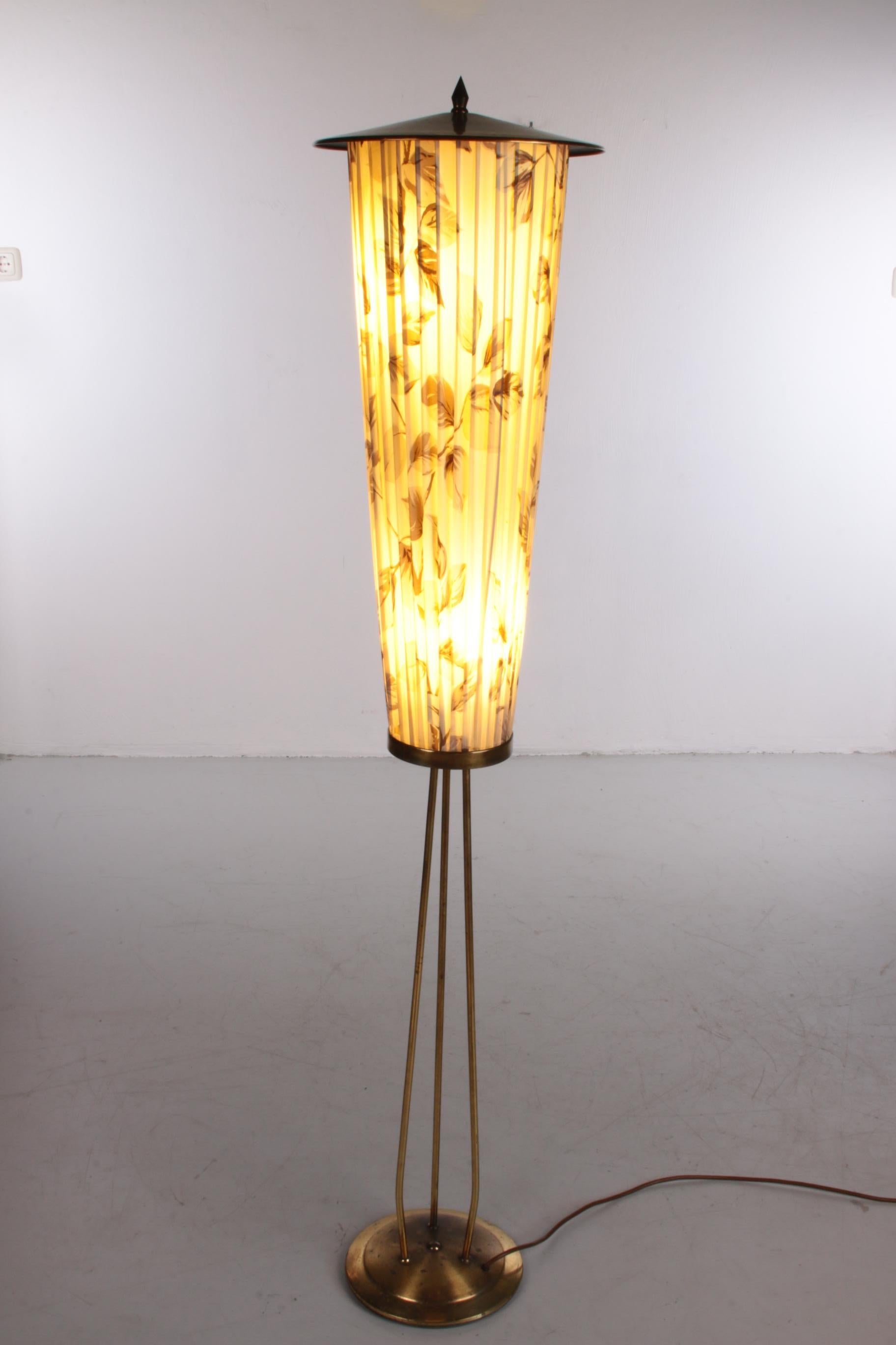 This unique lantern floor lamp comes from Germany, where it was produced around the 1960s.

The frame of the lamp is made of brass, which gives the frame of the lamp a beautiful golden color. The lampshade is made of fabric with a nature print on