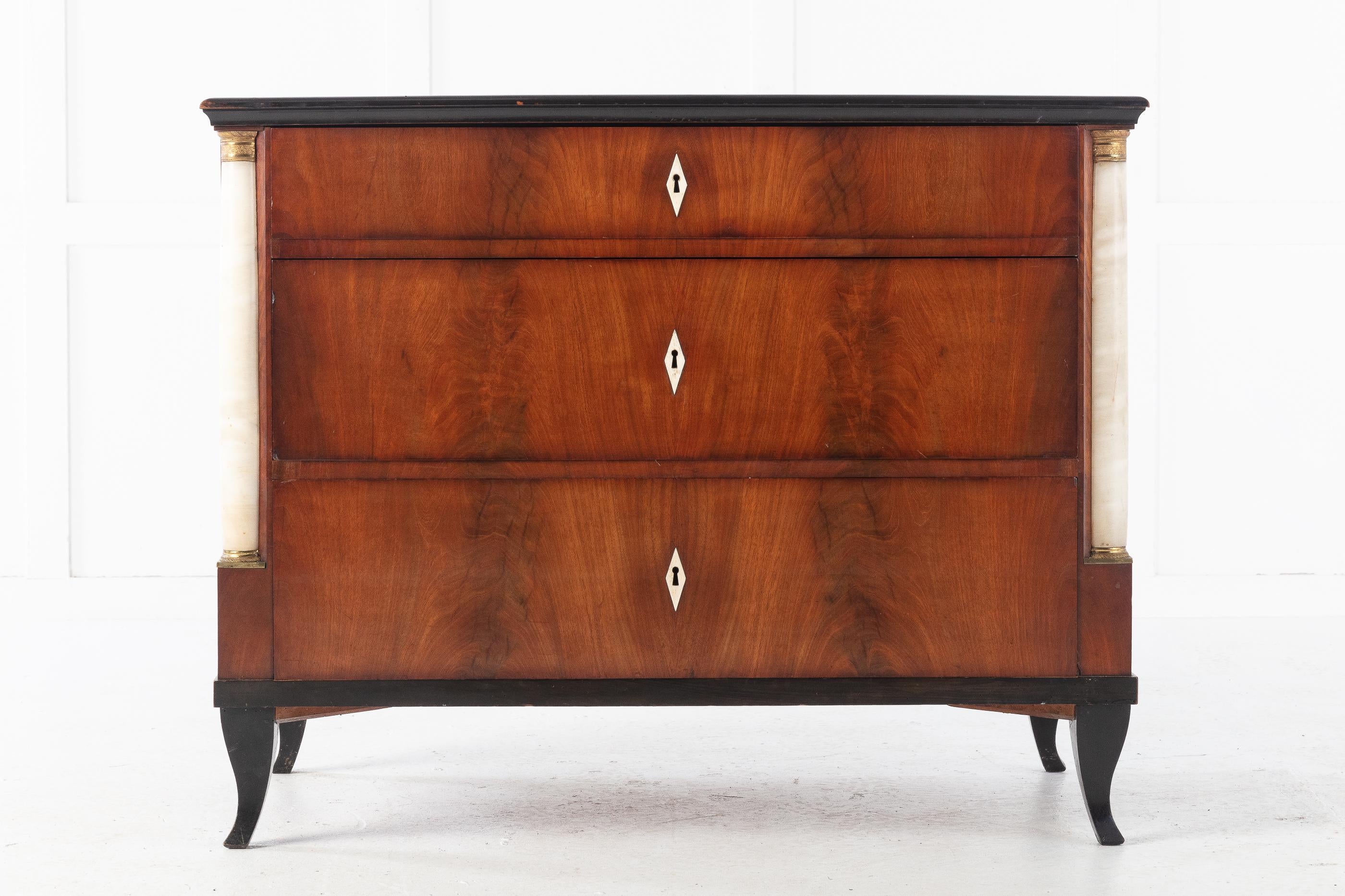 An excellent and very elegant example of this German mahogany Biedermeier chest, circa 1820. It has a very nice use of veneers.

The drawers are flanked by bronze detailed alabaster columns. Standing on splayed feet with ebonized detail.

Nice