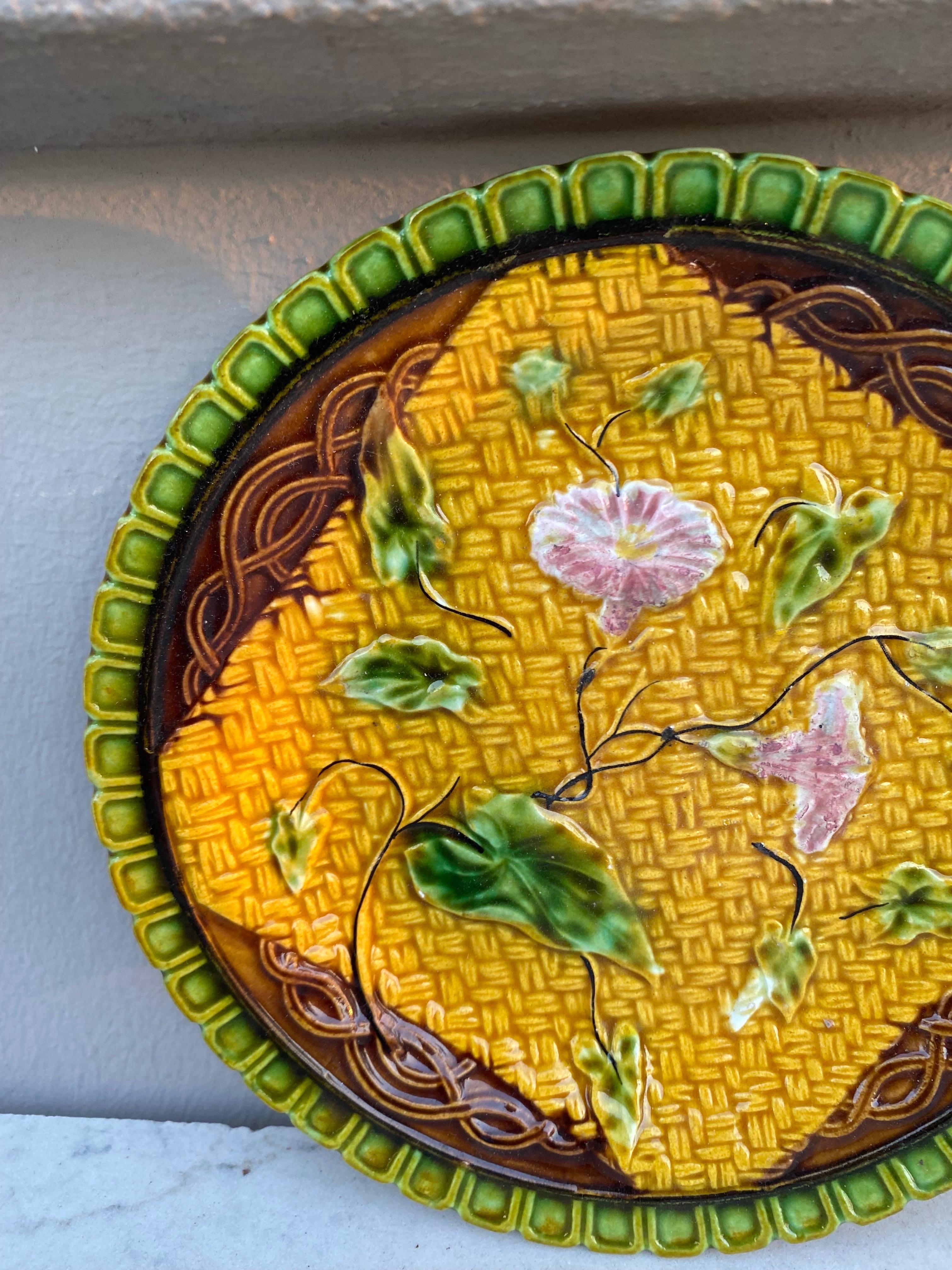 German Majolica plate with morning glory on a yellow basket weave and a green border, circa 1900.
