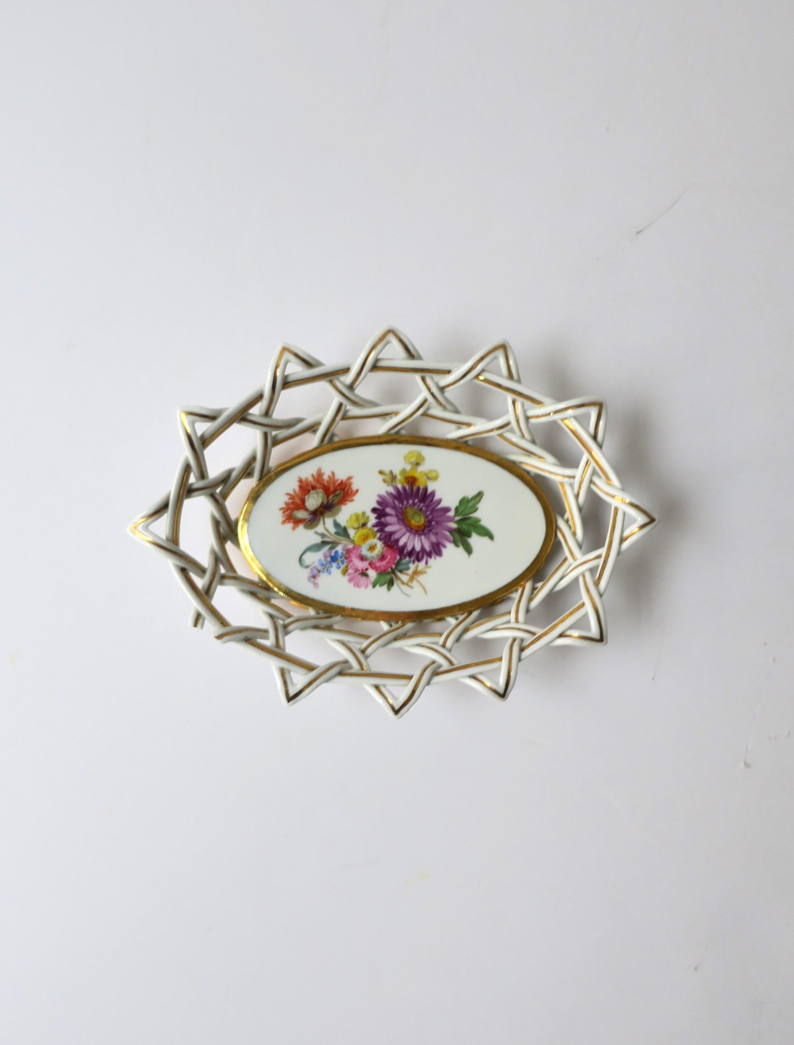 A German Meissen porcelain soap dish with latticework design and floral center, circa 20th century, Germany. This beautiful piece is oval, with lattice work around and gold detail, a multicolored bouquet of flowers at center and thick gold edge, on