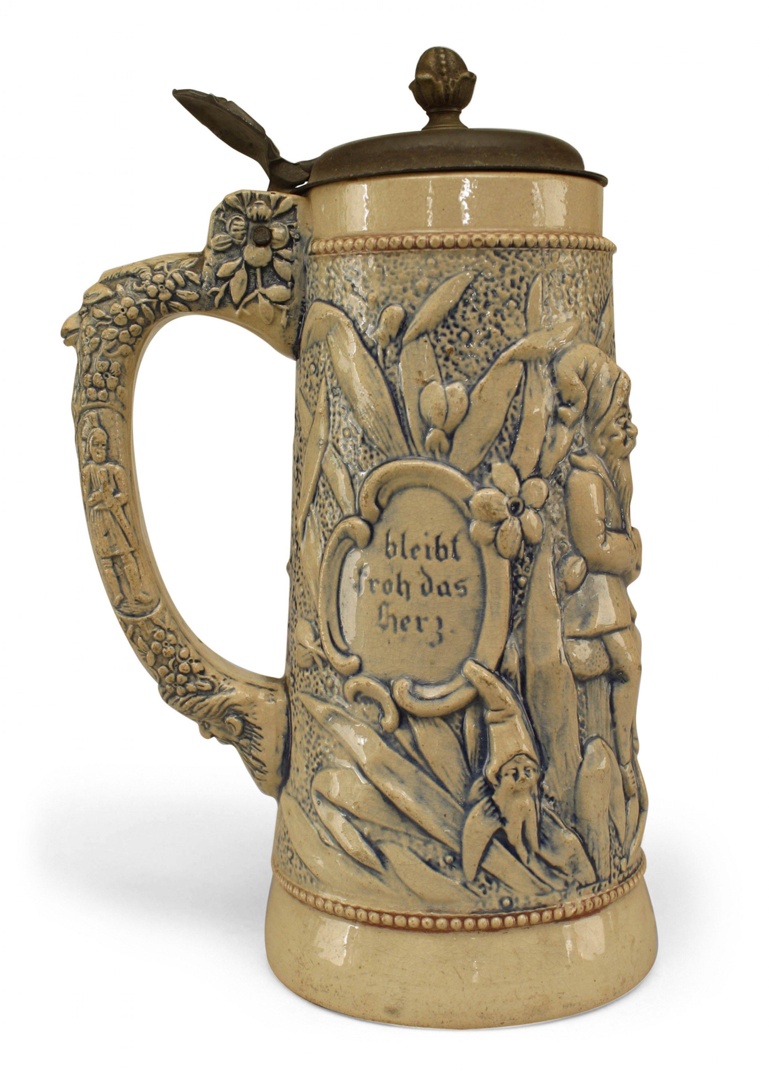 German (20th century-possibly by ADOLF DIESINGER) beige and blue porcelain beer stein with scene of 2 figures drinking and 1 playing guitar with pewter cover (Estate of Rober Ripley).
 