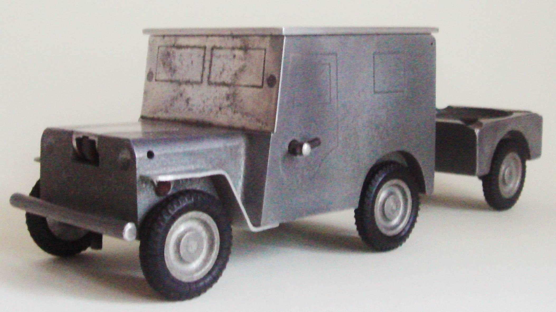 This German midcentury aluminum jeep table smoker's set features a stylized Willis Jeep in aluminum on four rubber wheels and is complete with a spare wheel mounted to the back. When the Jeep's roof is lifted it reveals a cigarette box and when its