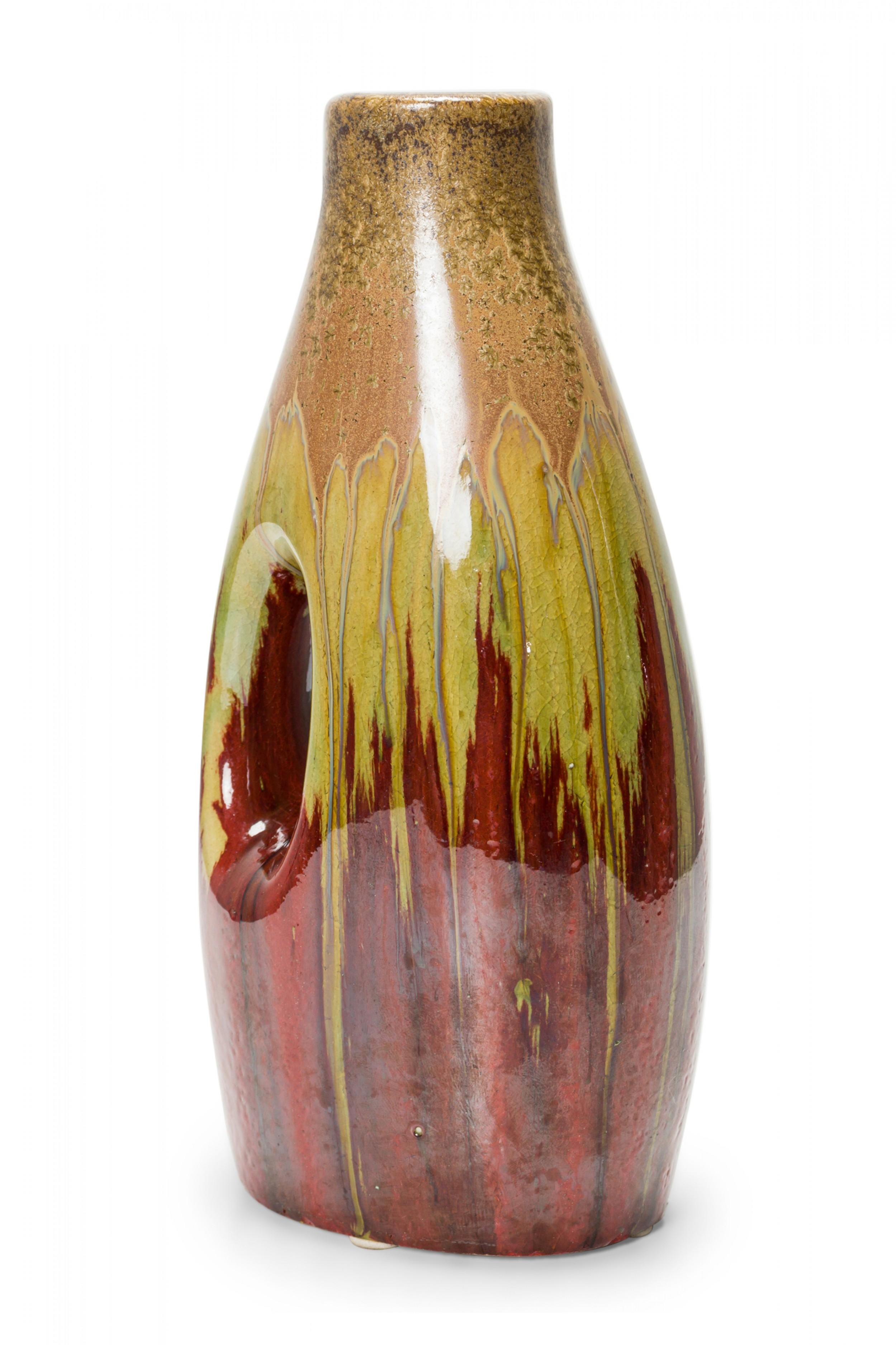 German mid-century ceramic vase with a cut out oval space and a green, beige, and brown drip glaze.