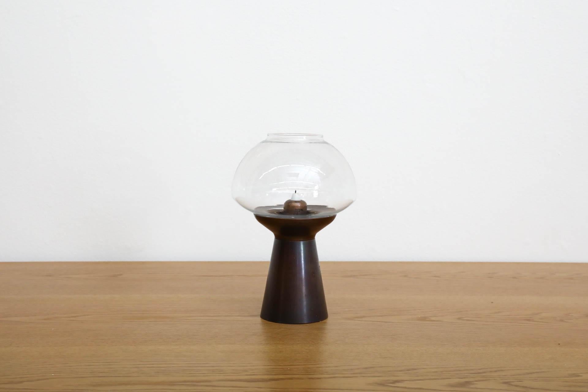German, Mid-Century Copper and glass mechanical candle holder by the Föhl company. Ingenious design that has a spring-loaded mechanism which moves the candle up as it burns. Design shares a resemblance with Model L102/32 Candle light by Hans Agne