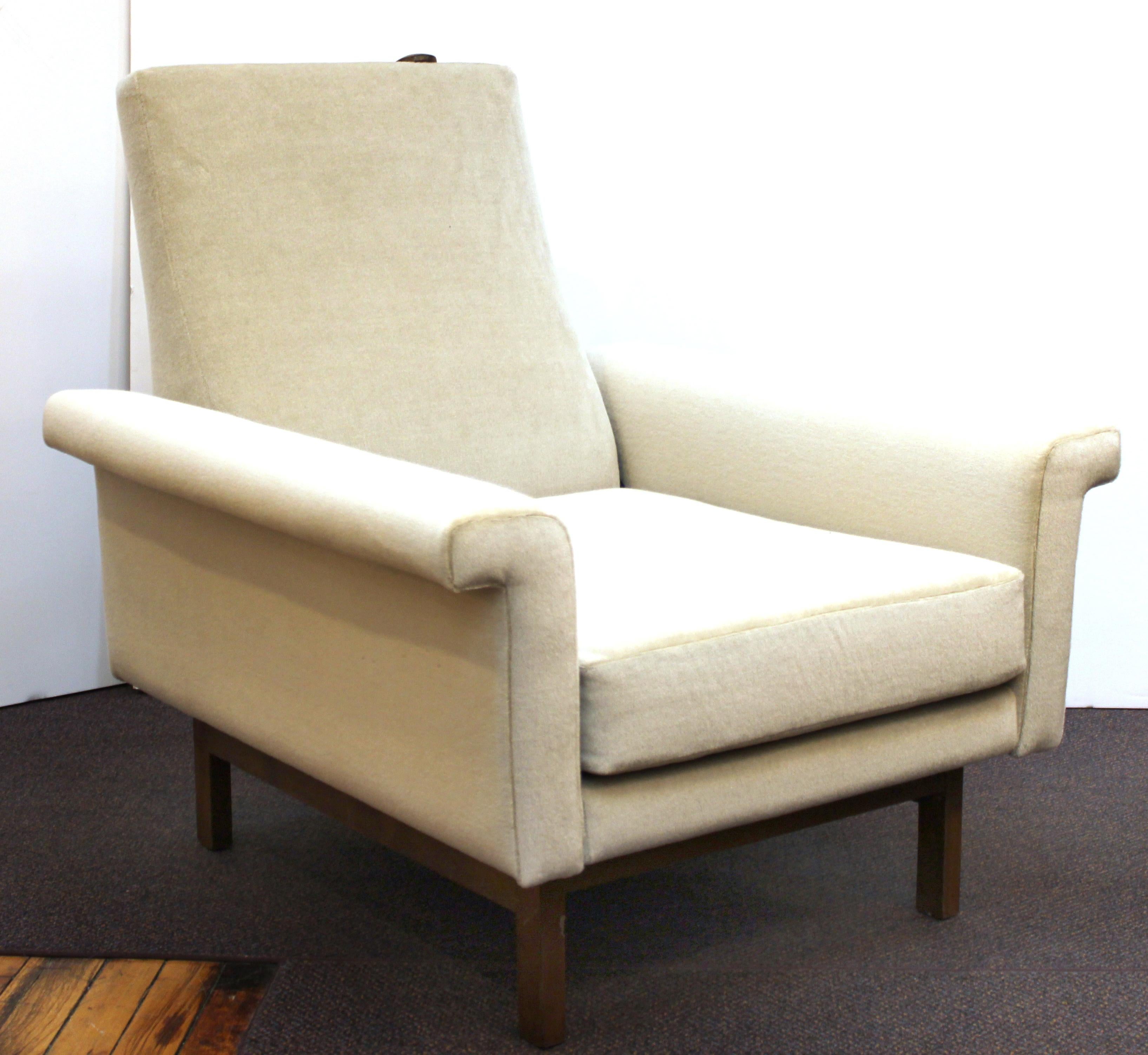 Mid-Century Modern lounge armchair with matching ottoman, designed and made in Germany in the mid-20th century. The armchair has a reclining function with a button on the top of the backrest. 'Made in Germany' label on the bottom. The pair is in
