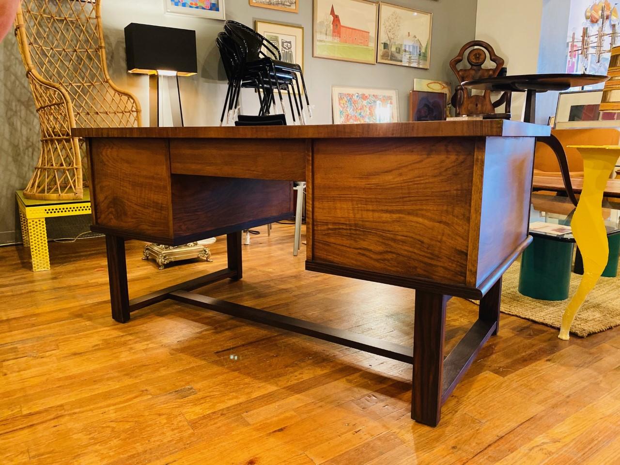 Beautiful mid century black walnut desk. This modernist desk is captivating and stylish. While sleek in lines, the desk has a strong grounding presence that defines its architectural lines. The fully finished drawers provide an incredible amount of