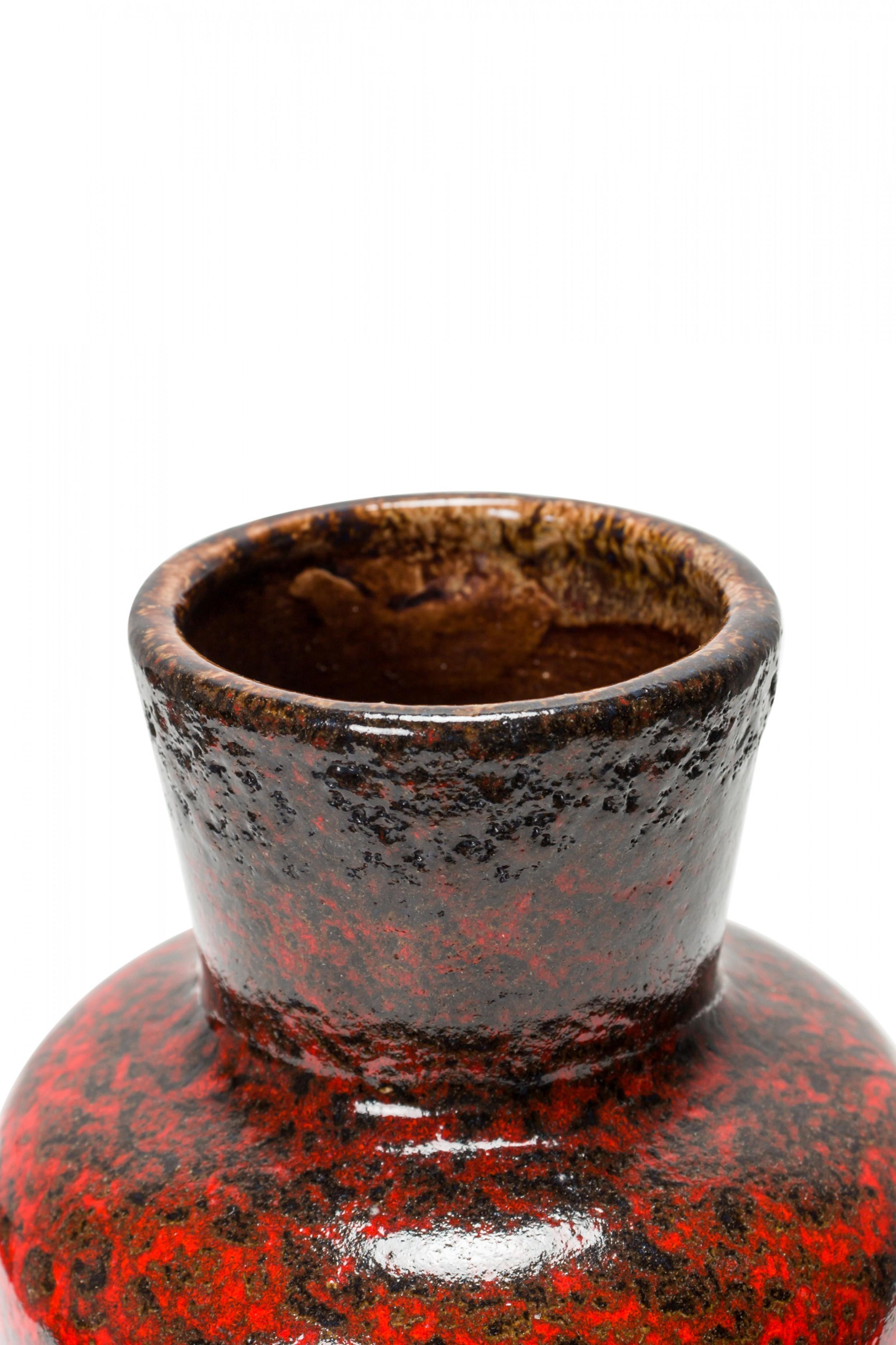 German mid-century ceramic urn-form vase with an extended flared mouth and a red and black fat lava-style glaze.
