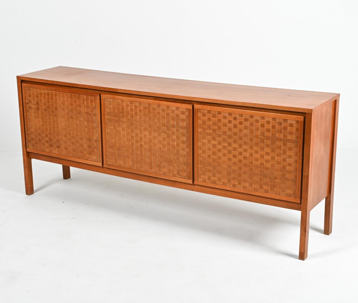 The epitome of casual sophistication, this exceptional teak sideboard was designed by the visionary Leo Bub and meticulously crafted in Germany during the 1960's. 

Crafted from lustrous teak, this sideboard boasts a striking basketweave front,