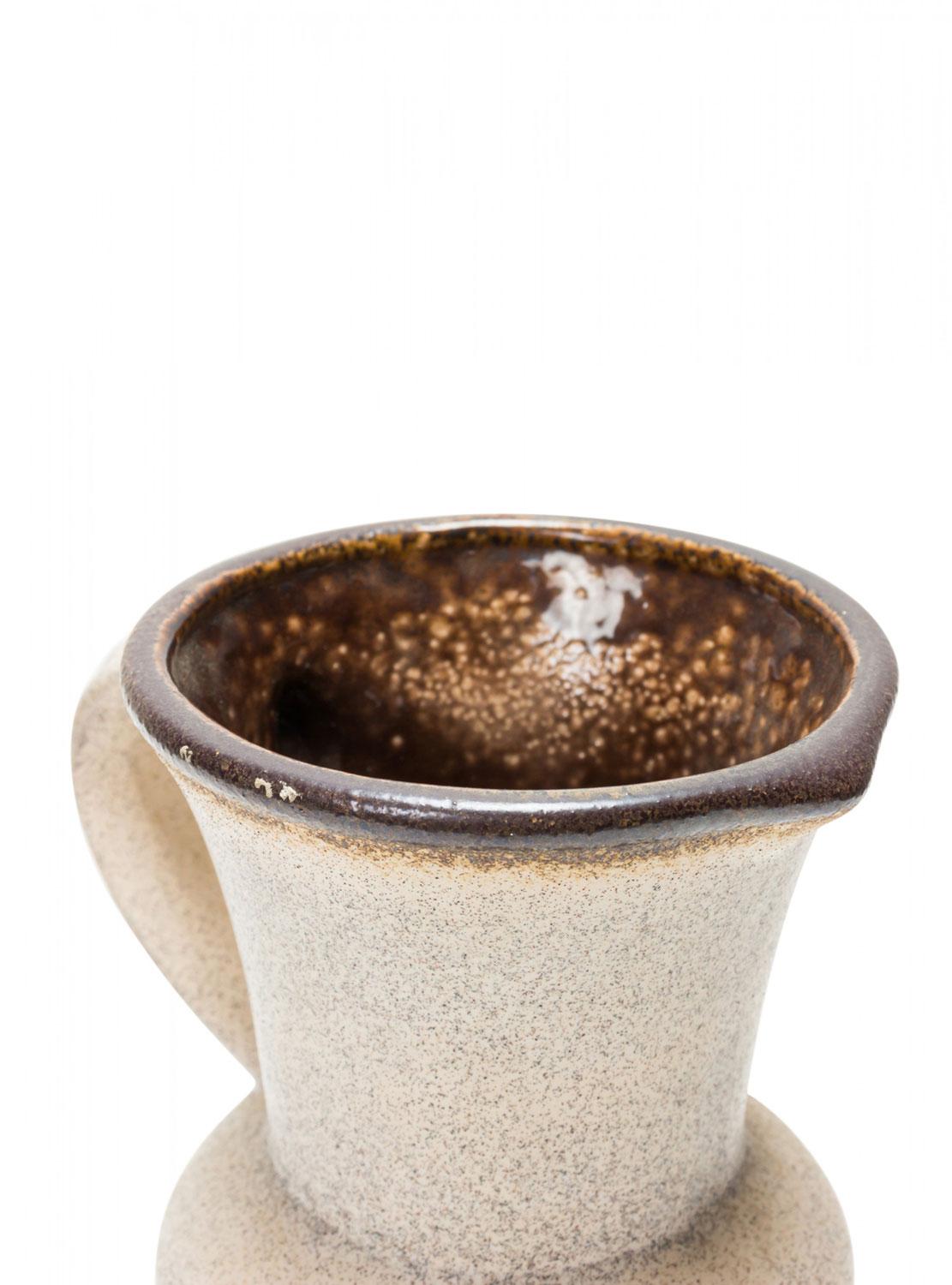 Brocca in ceramica tedesca della metà del secolo scorso con una fascia marrone e rossa intorno al corpo, sotto l'apertura svasata e il manico con finitura beige e interno marrone. (numerato sul fondo)