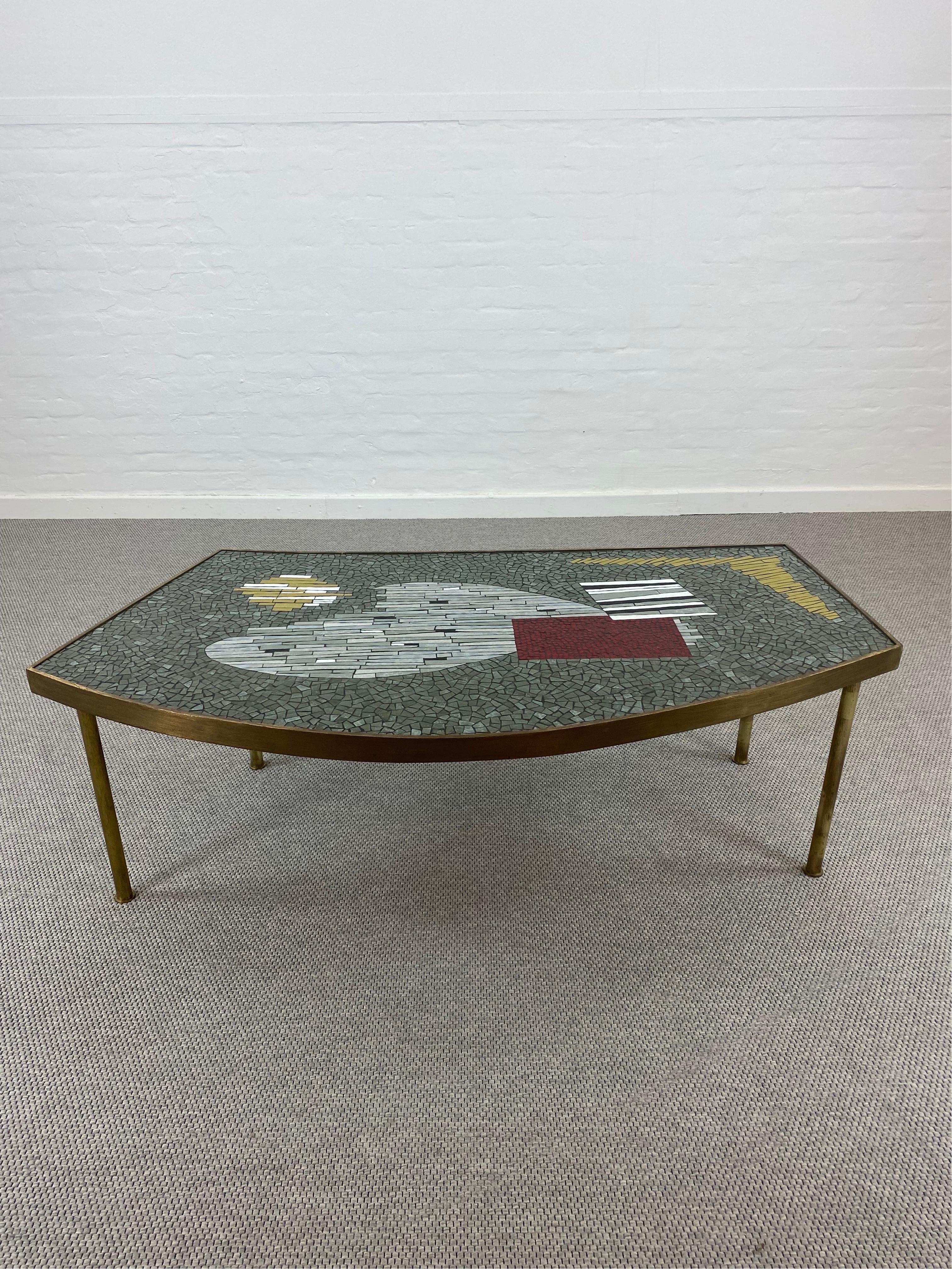 A 1950s Glas-Mosaic table by German Artist Berthold Muller-Oerlighausen (1893-1979).
Very nice colors and a elegant form is here combined to create a nearly perfect icon of the 1950s.
The glas tiles inlay give this table a brilliant depth and show