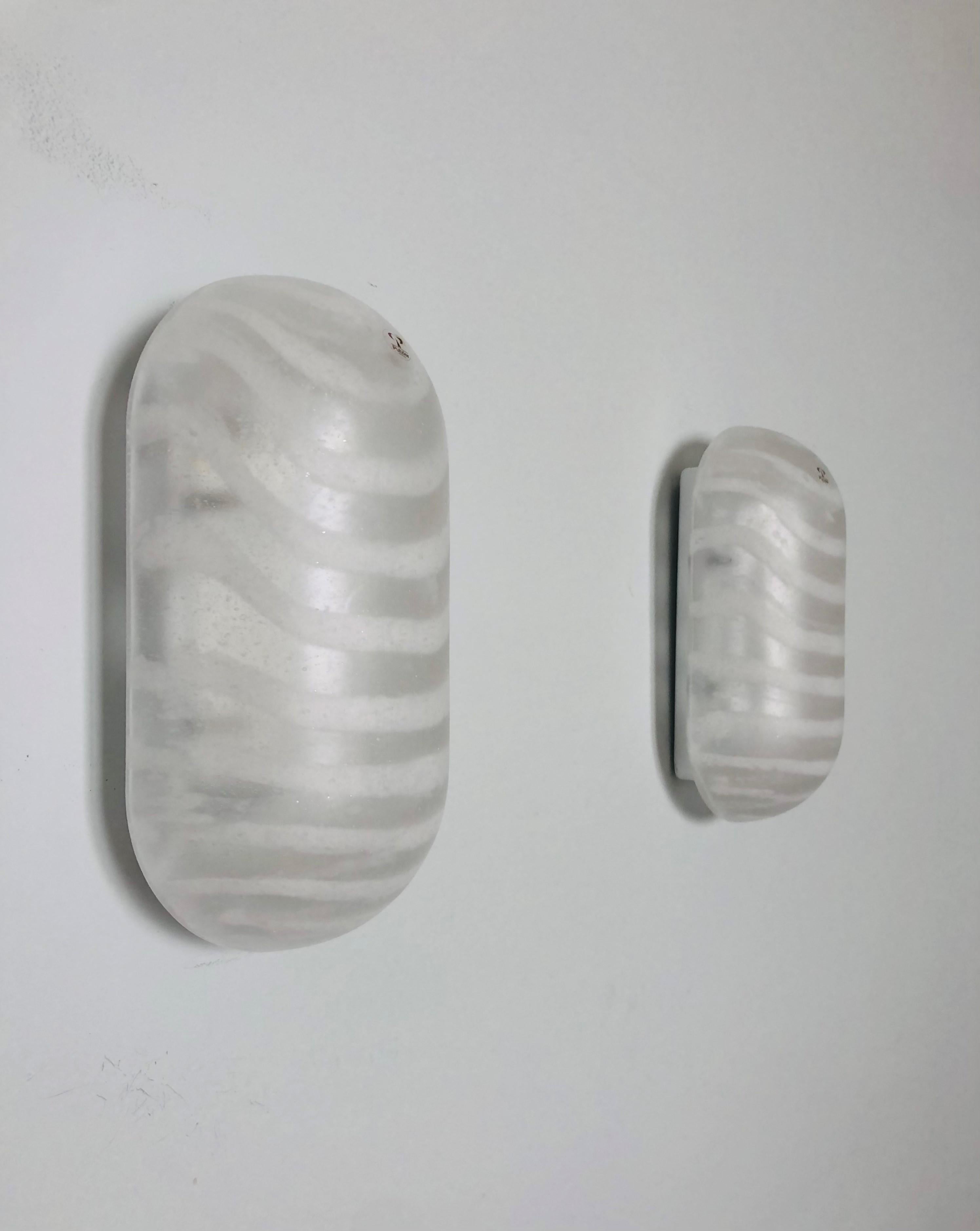 Bellissima e unica coppia di applique tedesche in vetro. Queste applique sono state progettate e prodotte in Germania da Peill & Putzler negli anni Settanta.
L'etichetta adesiva originale 