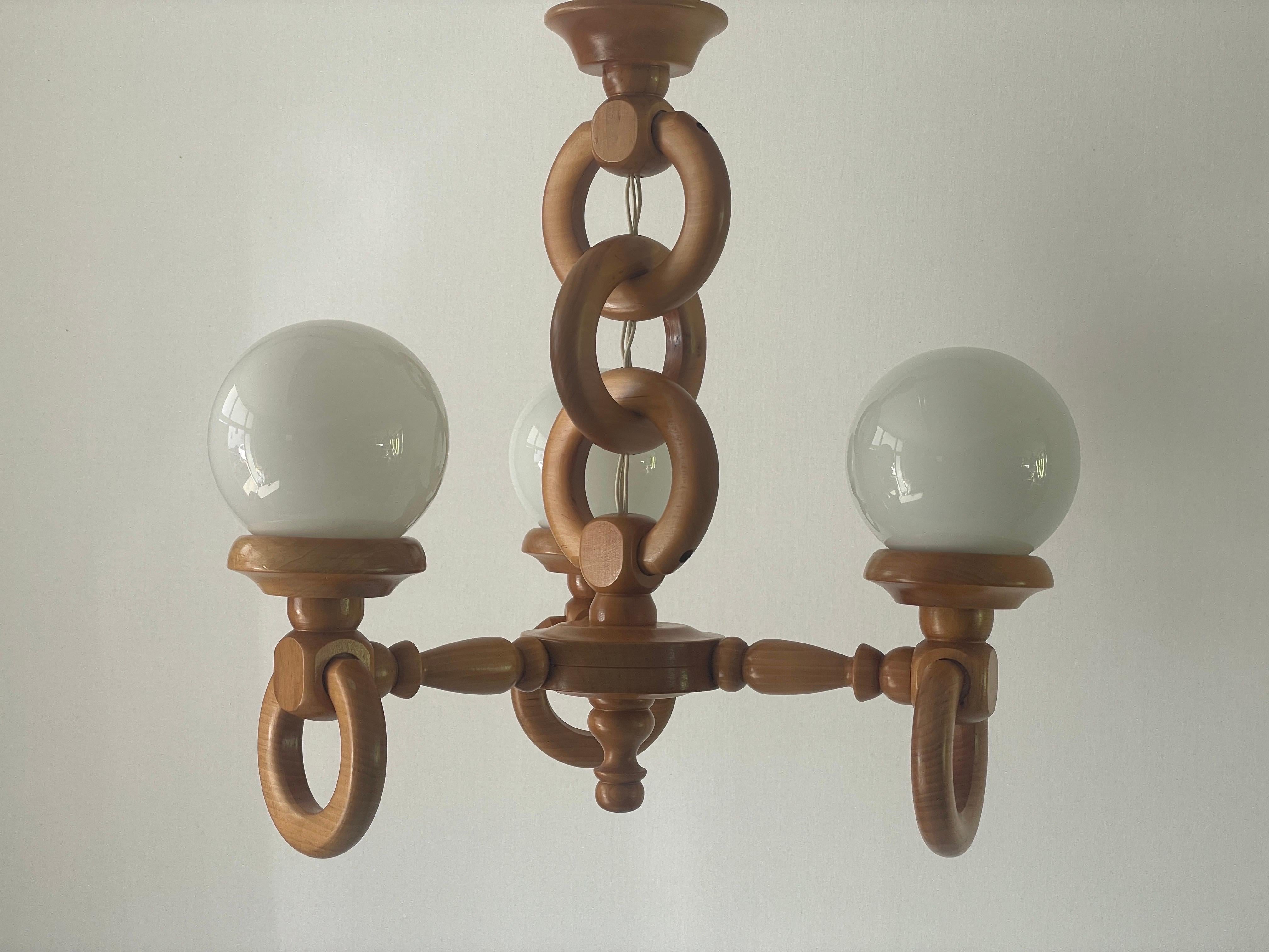 German Modern Triple Opaline Glass & Wood Chain Body Ceiling Lamp, 1970s, Germany

Lampshade is in very good vintage condition.

This lamp works with 3x E14 light bulbs. 
Wired and suitable to use with 220V and 110V for all